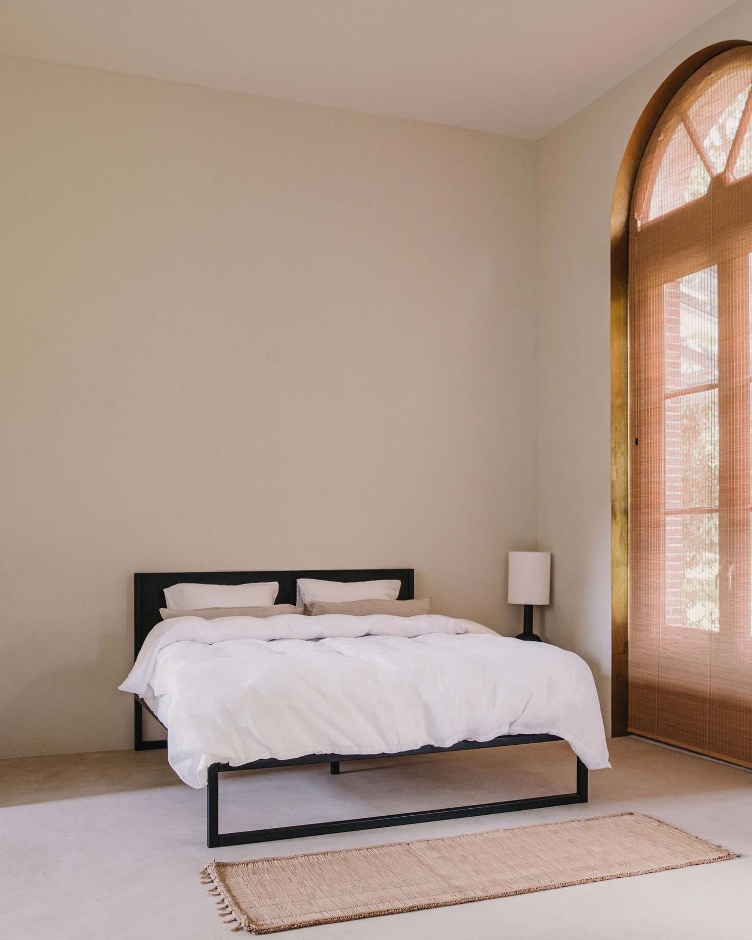 Bed staat in kamer naast grote deuren