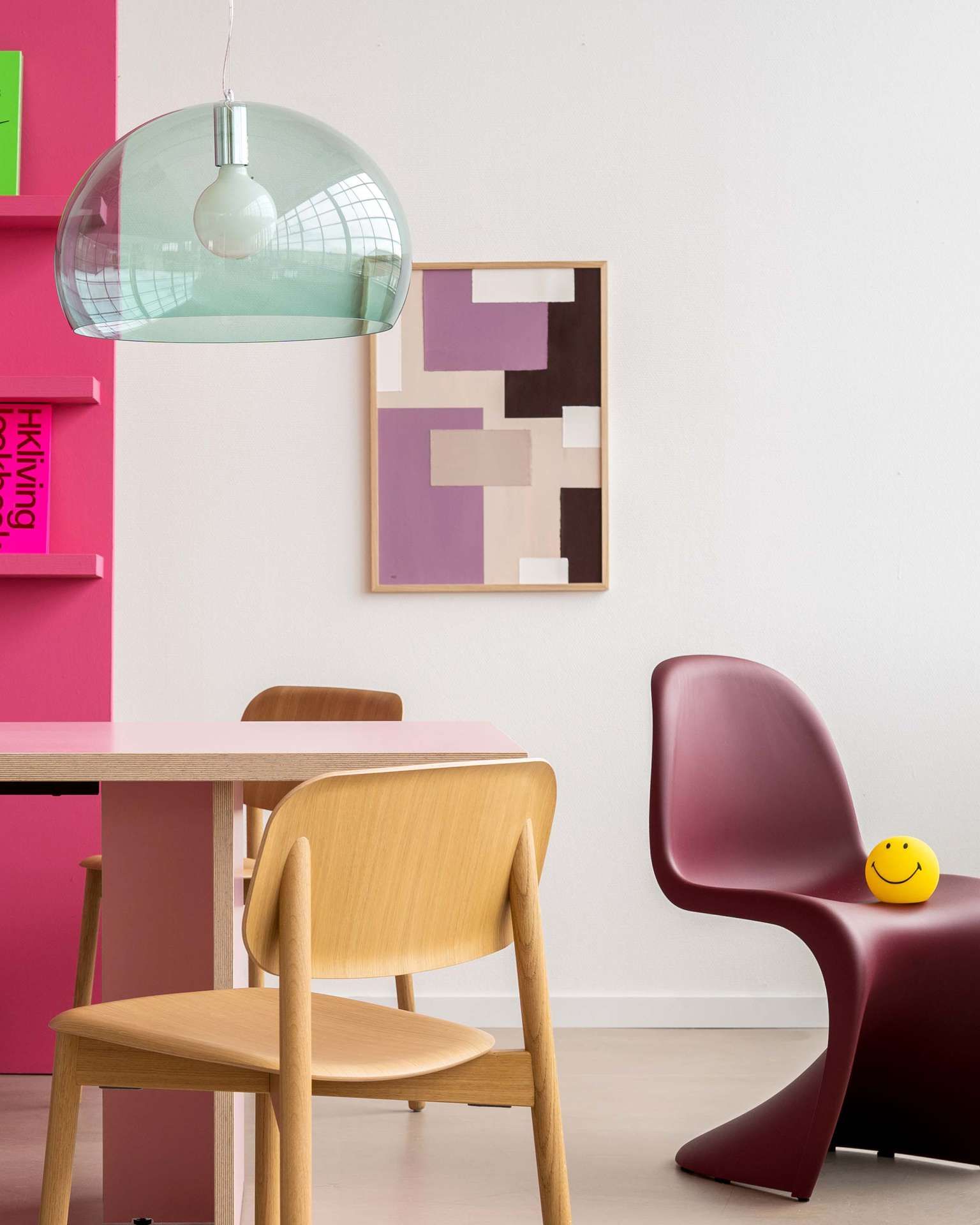 kamer met stoelen, hanglamp en kunst aan de muur