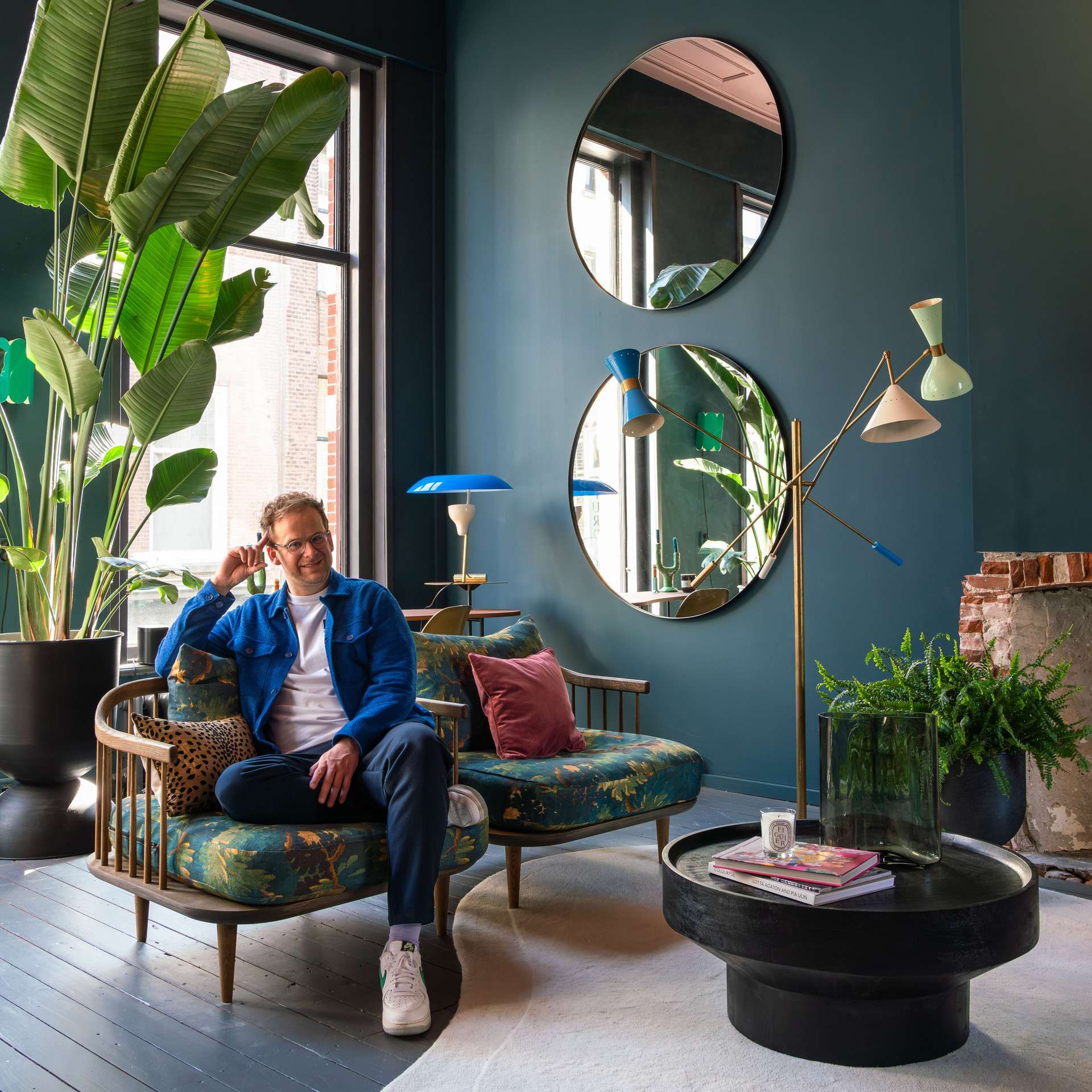 Theo-Bert zit in fauteuil in zijn groen-blauwe interieur