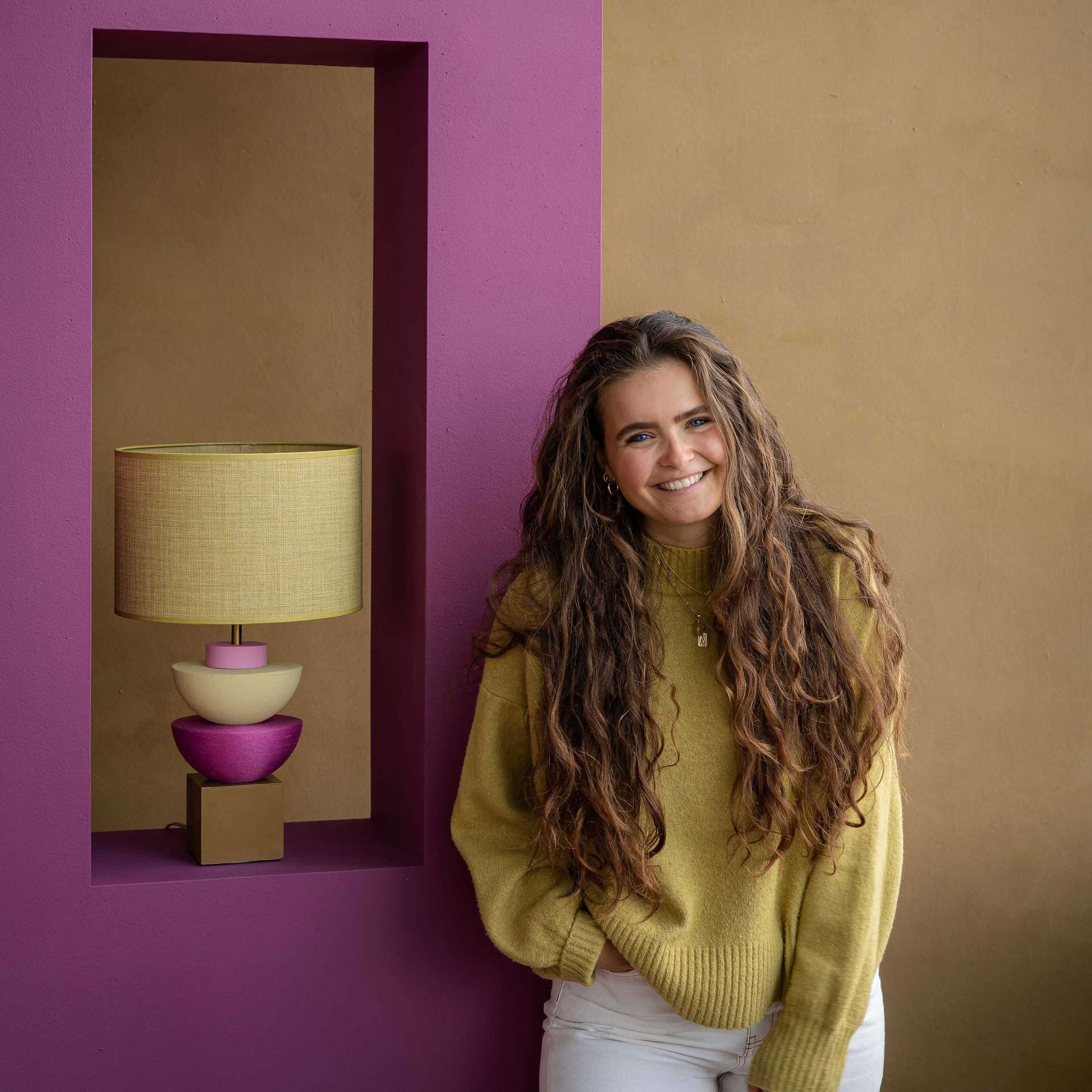 Vrouw voor paarse muur met lamp