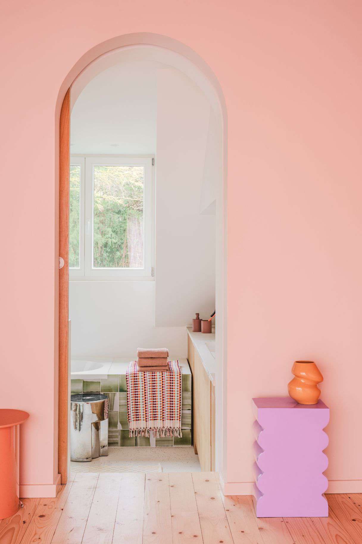 doorkijkje naar badkamer met handdoeken en bijzettafels