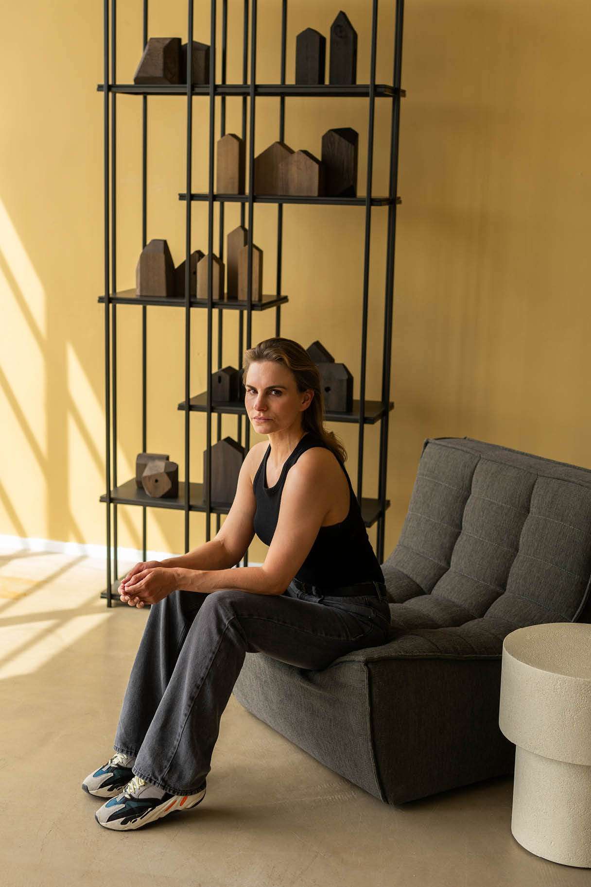 vrouw zit op fauteuil naast kast
