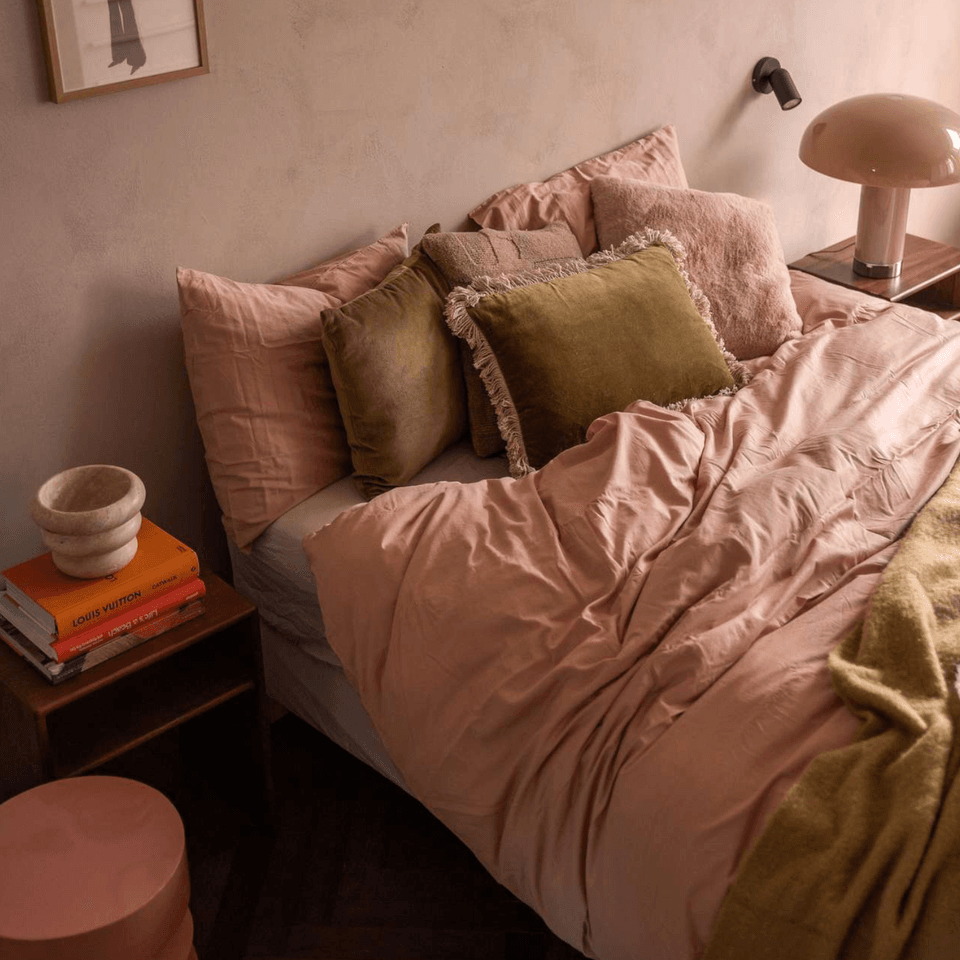 roze bed met groene kussens