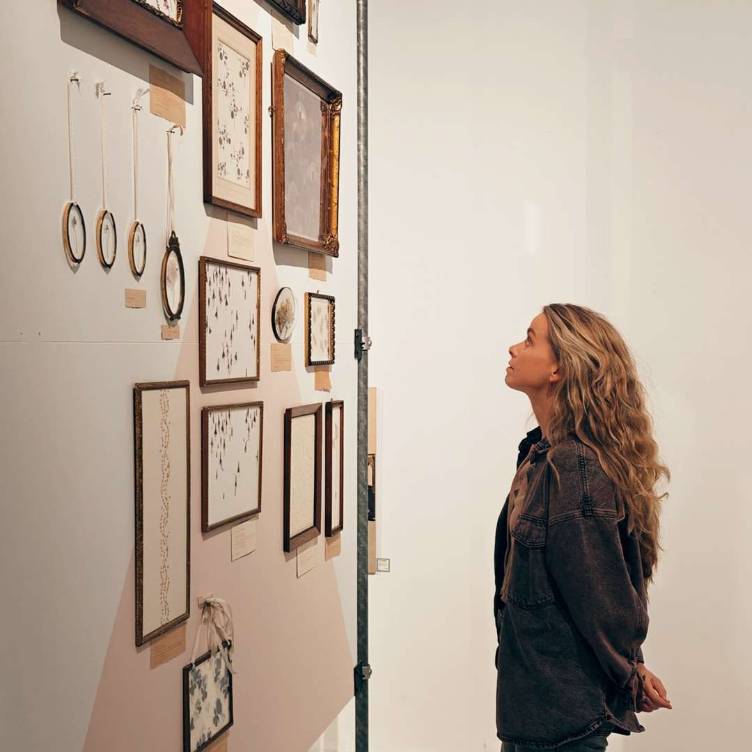 Vrouw kijkt naar muur met kunst