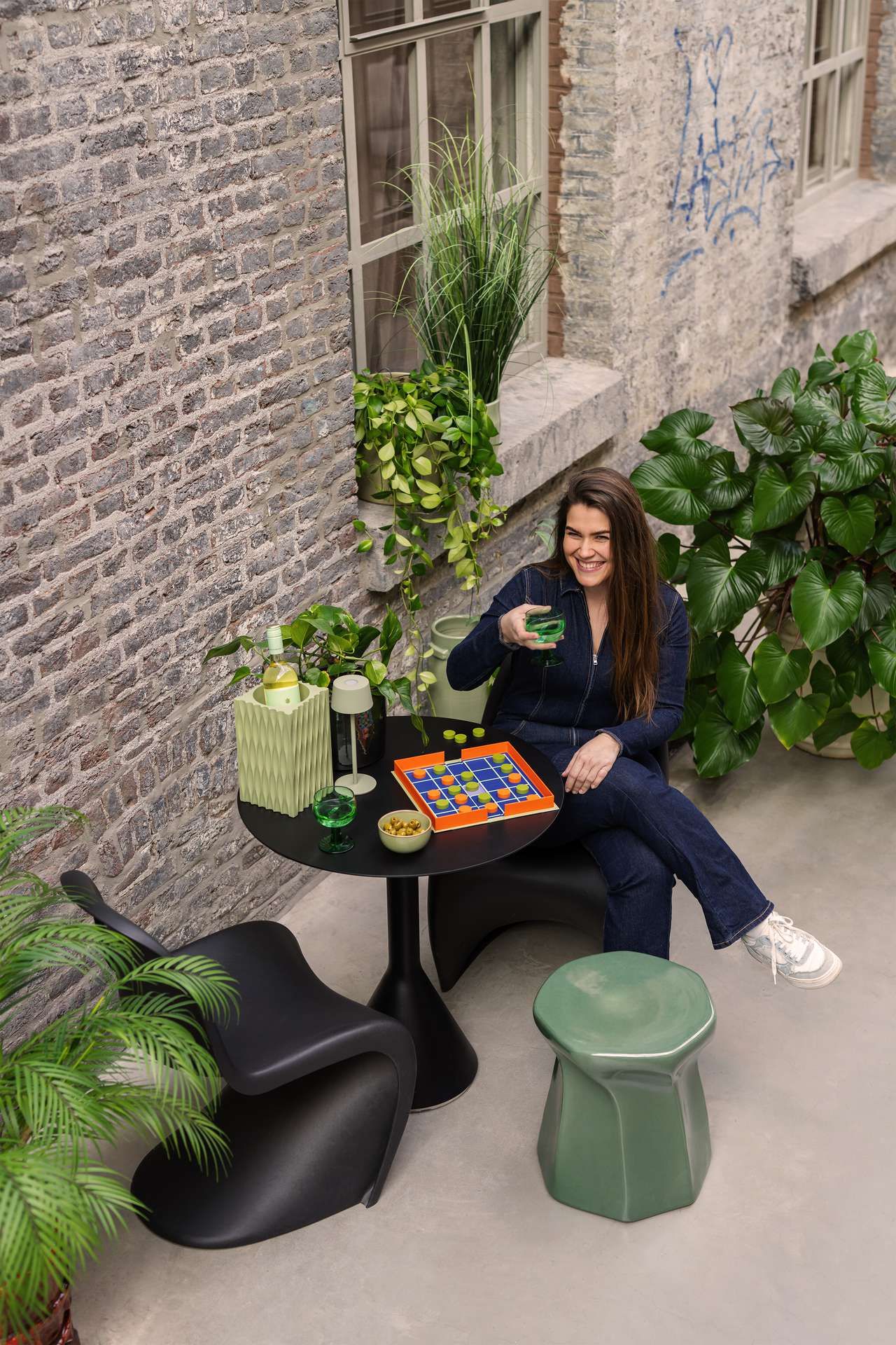 vrouw zit buiten aan een tafeltje een spelletje te spelen
