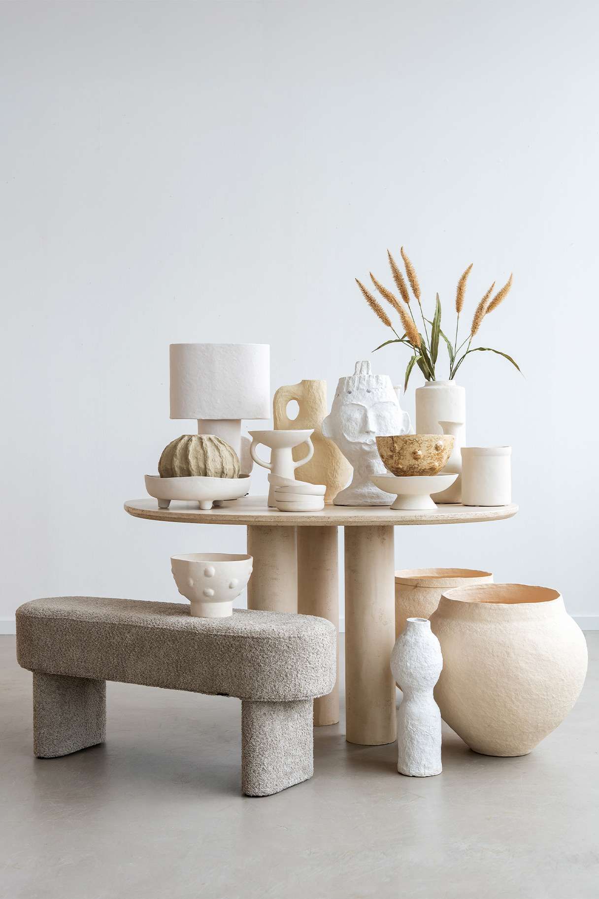 papier-mache items op een tafel met poefje ernaast