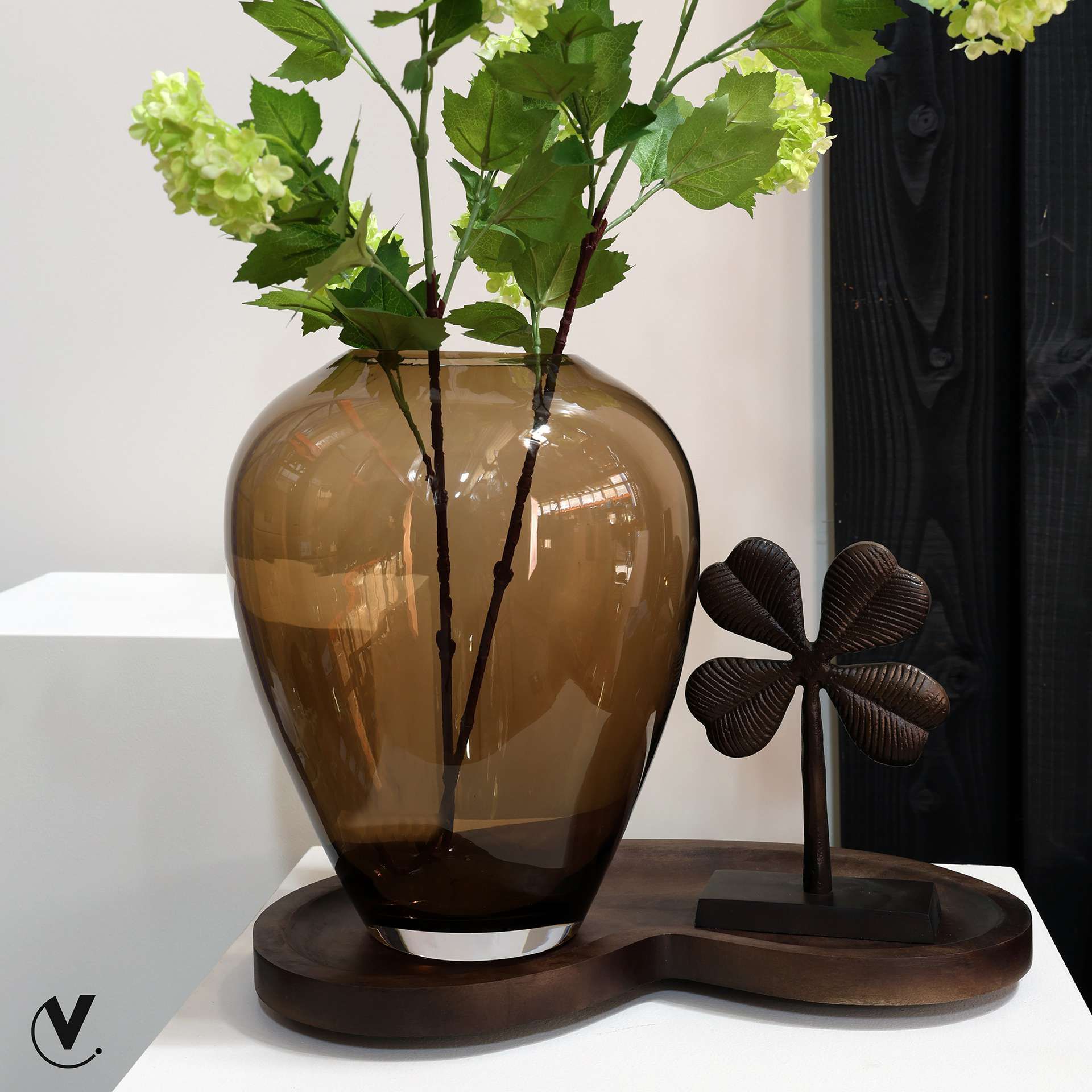 Transparante vaas van bruin glas met groene takken