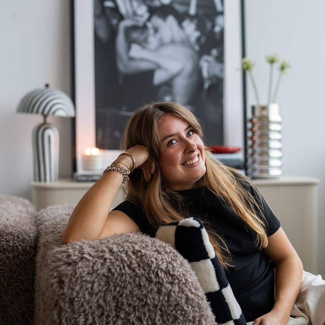 Vrouw zit op bank en lacht