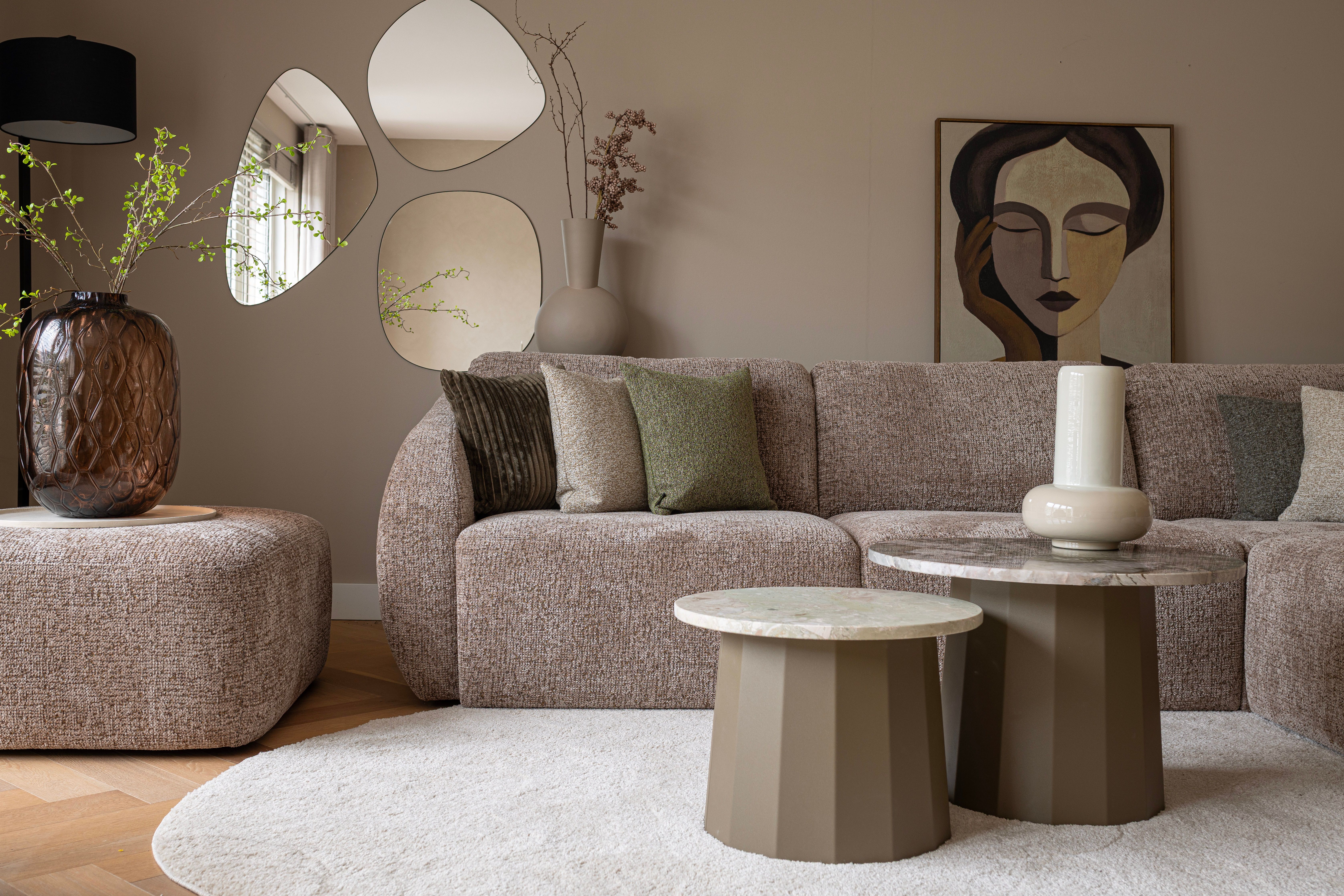 Lichtbruine bank in beige woonkamer met groene accenten