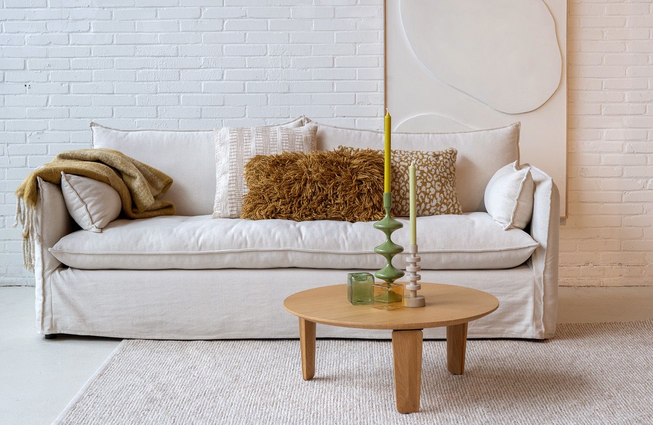 Beige 2-zitsbank met sierkussens en decoratie