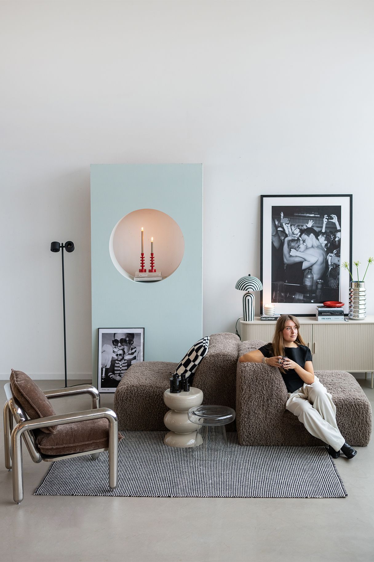 Vrouw zit op fauteuil in woonkamer