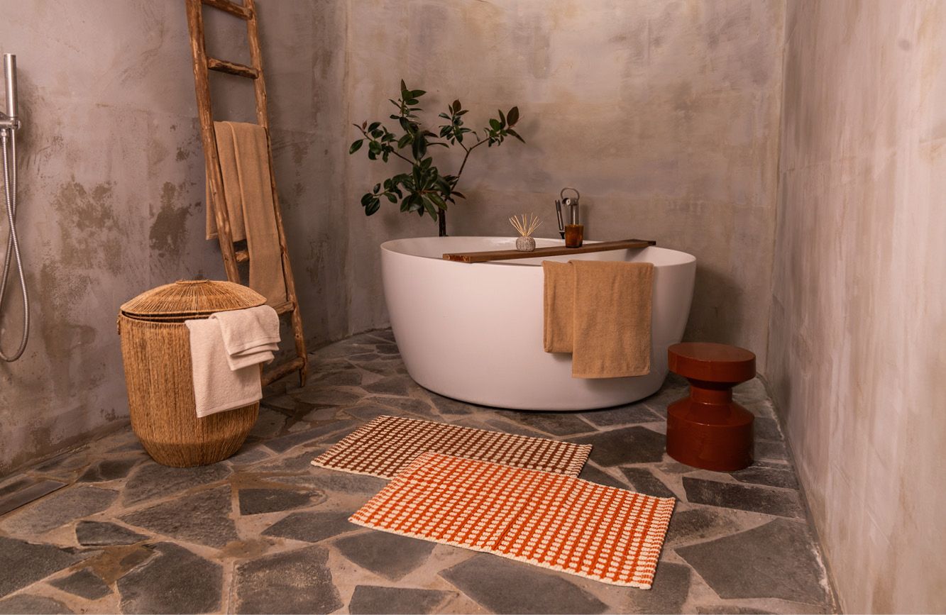 Badkamer met stenen vloer en accessoires en bad