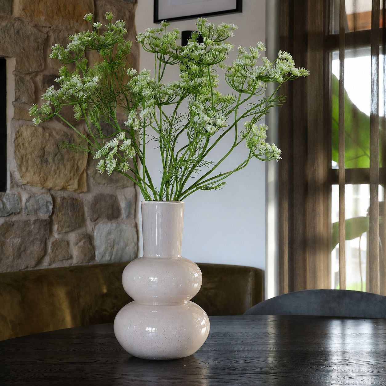 Beige glossy vaas met bollingen met groene takken erin