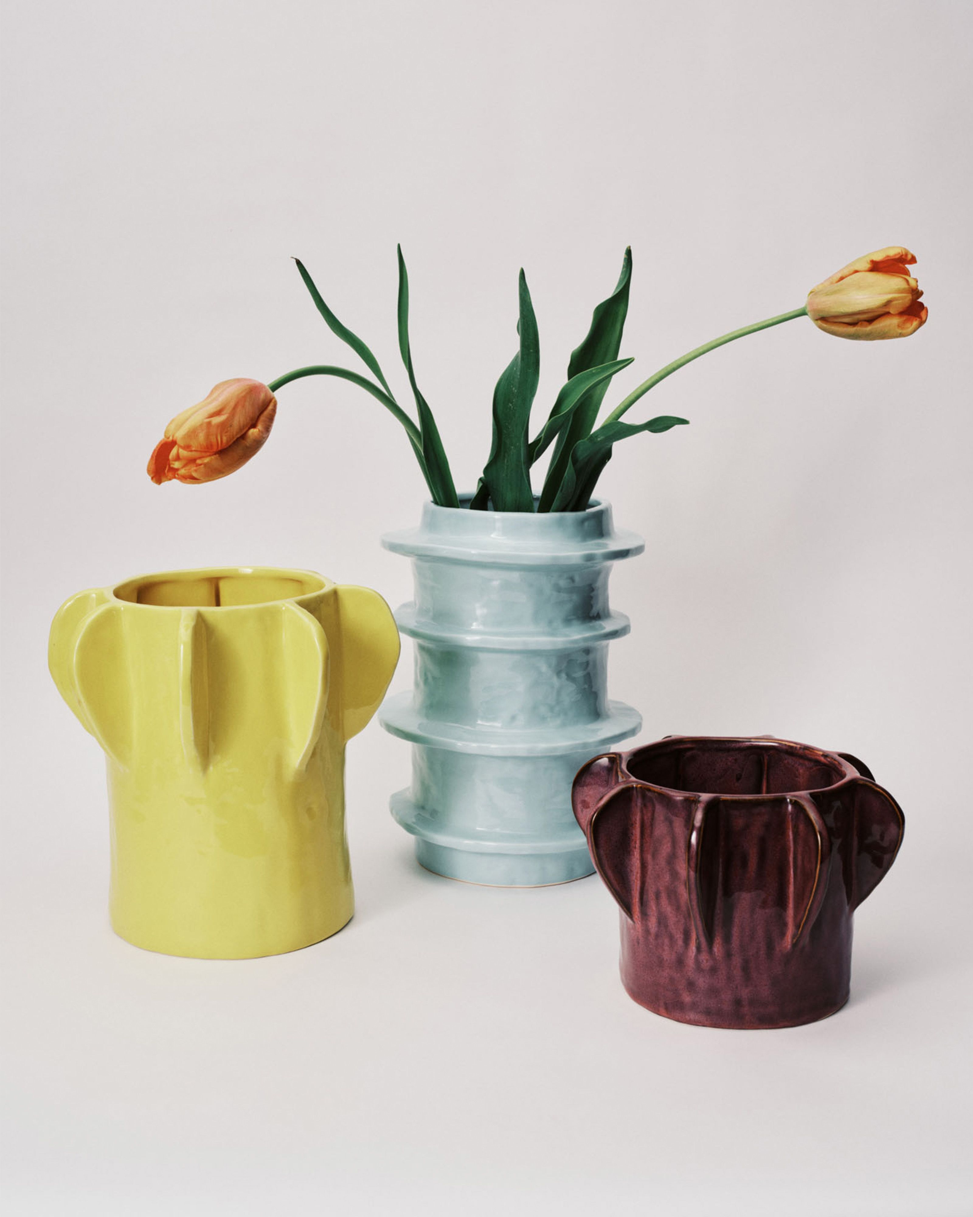 3 vazen/bloempotte in het geel, paars en blauw met bloemen erin