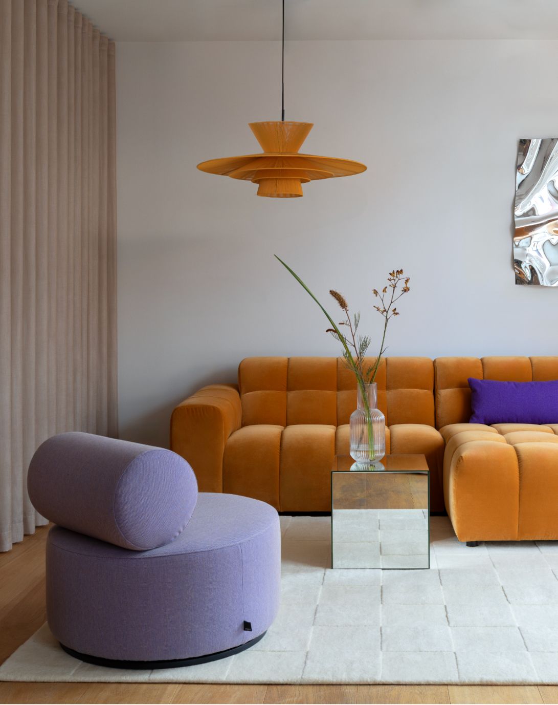 oranje bank en paarse fauteuil in woonkamer