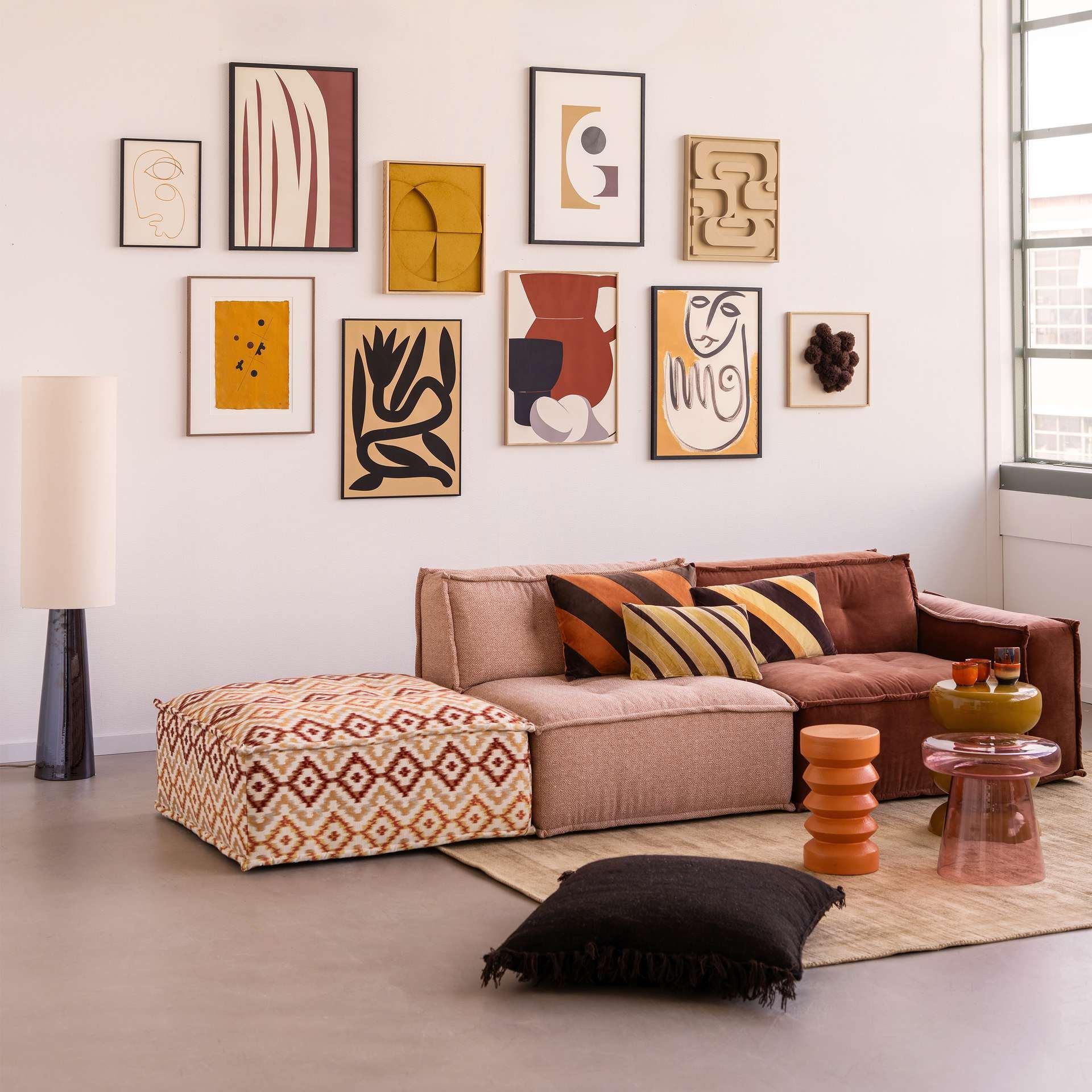 Woonkamer setting roze/rood tinten met kunst aan de muur