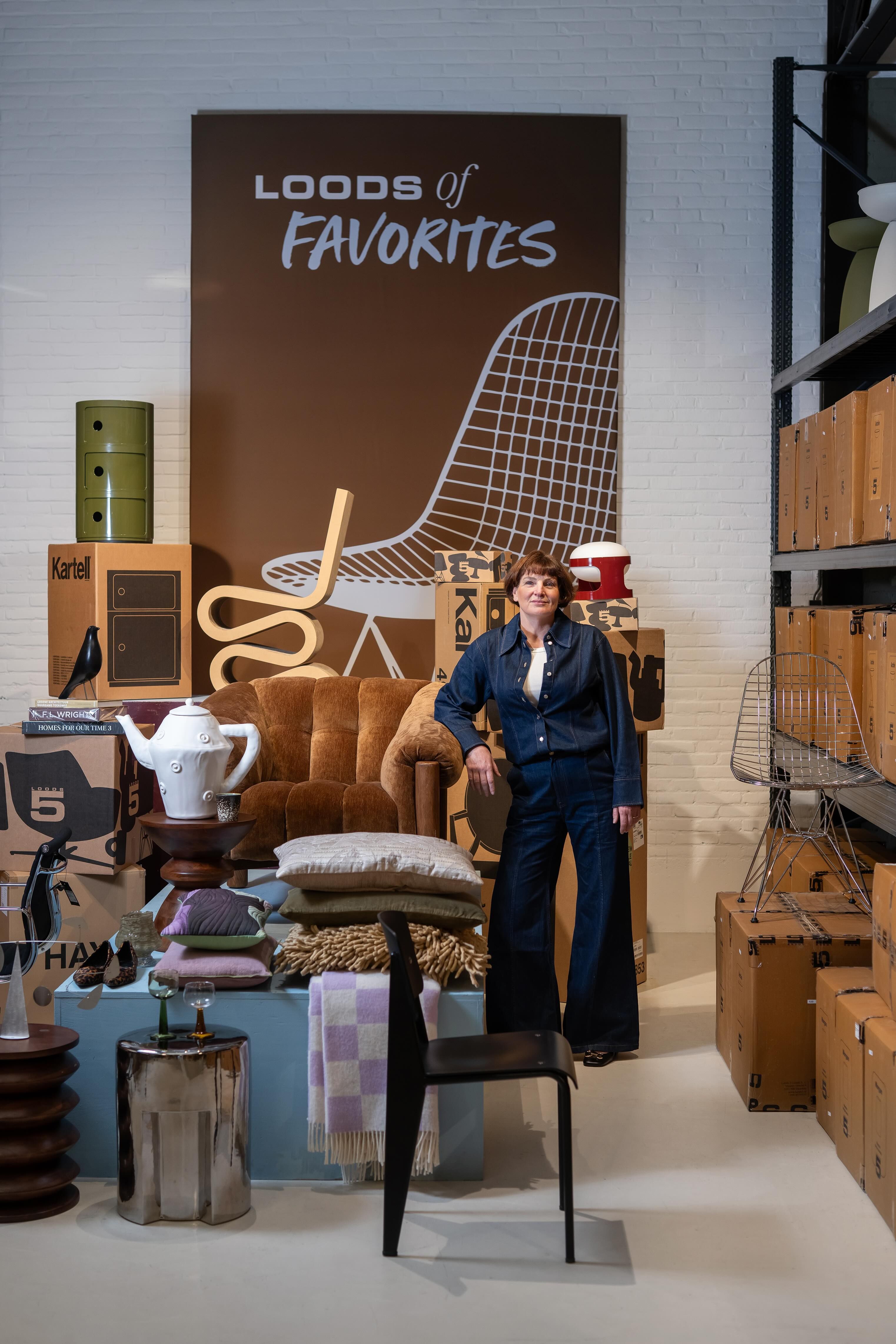 vrouw staat tussen verschillende meubels en accessoires