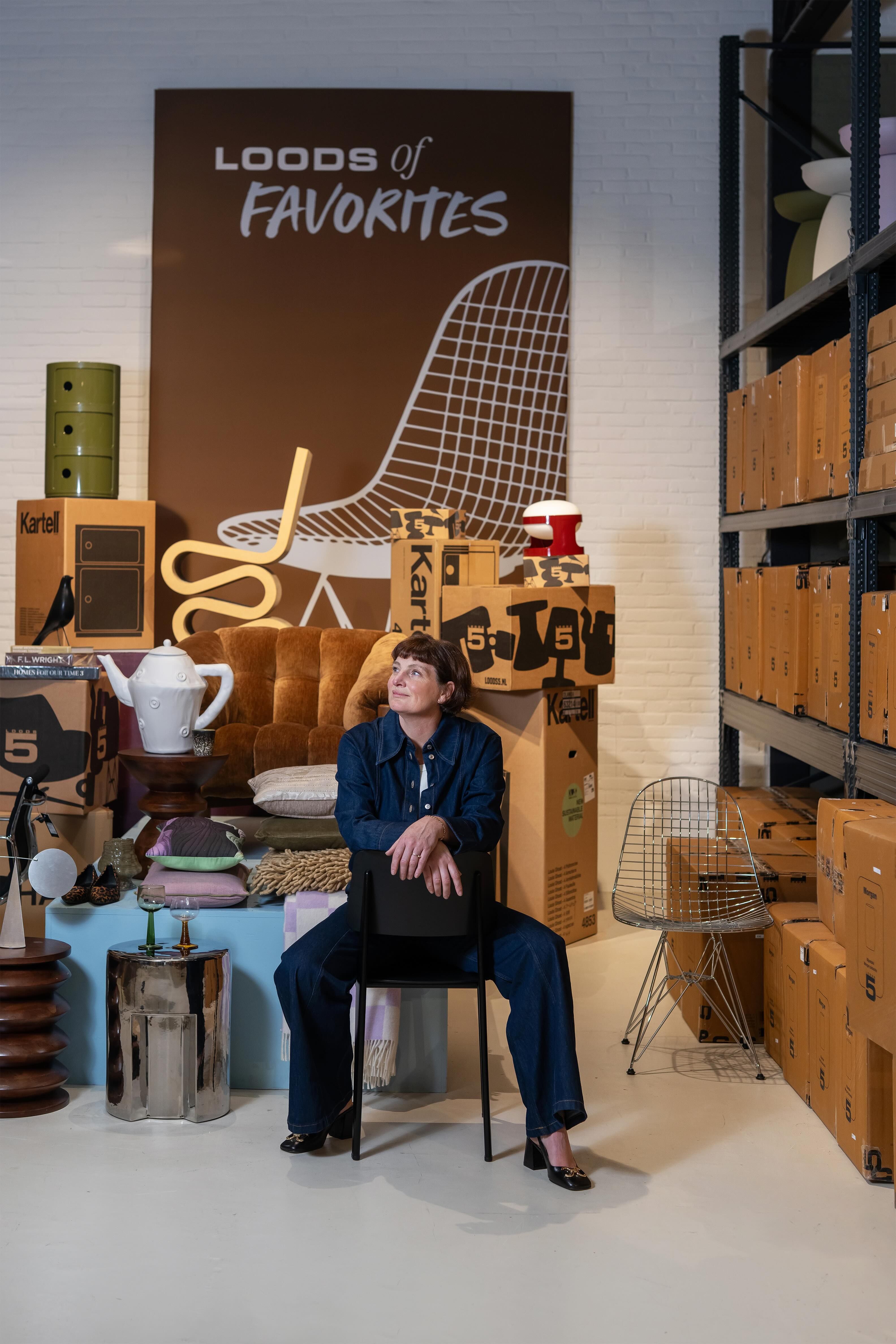 vrouw zit tussen verschillende meubels en accessoires