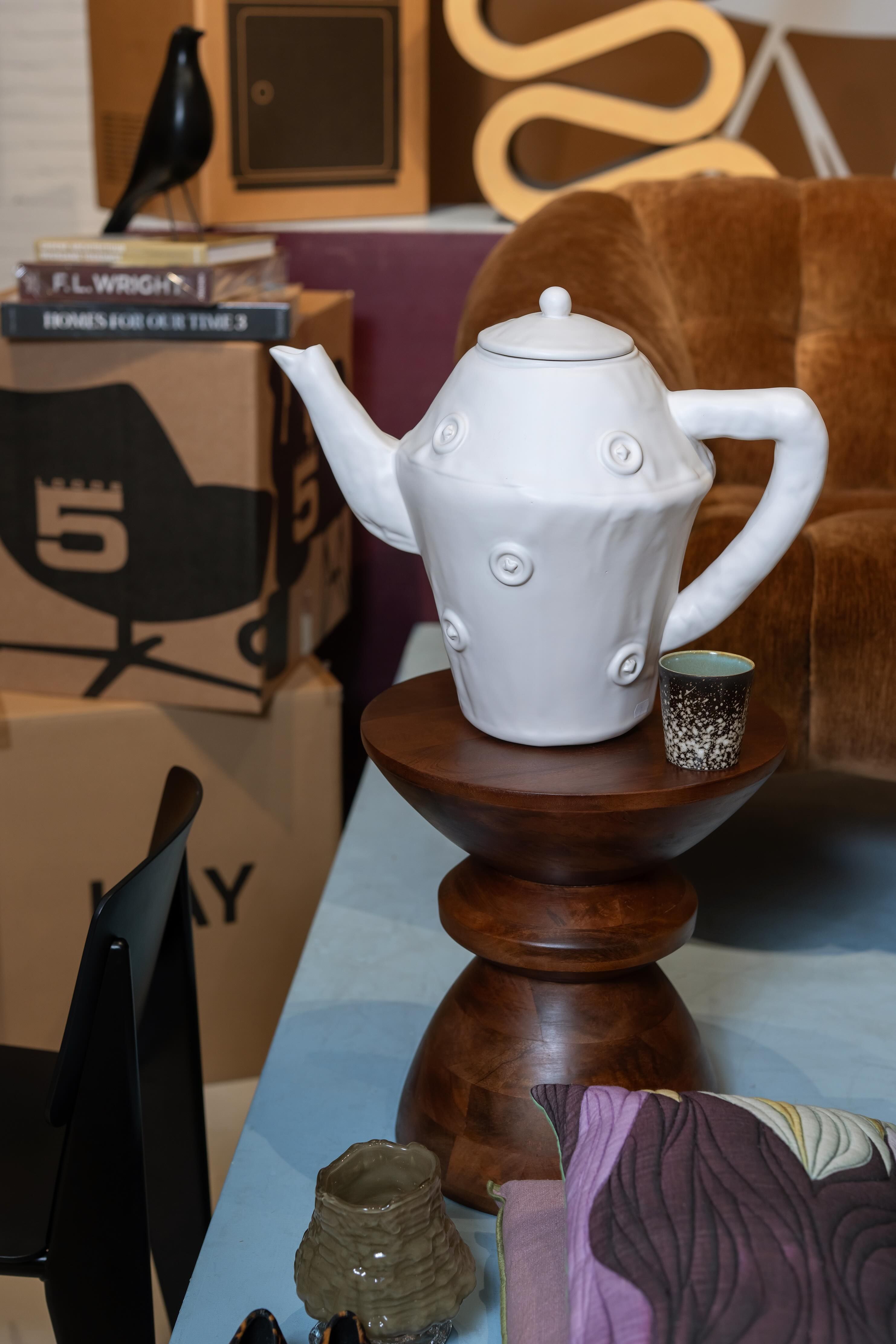 witte theepot op houten bijzettafel