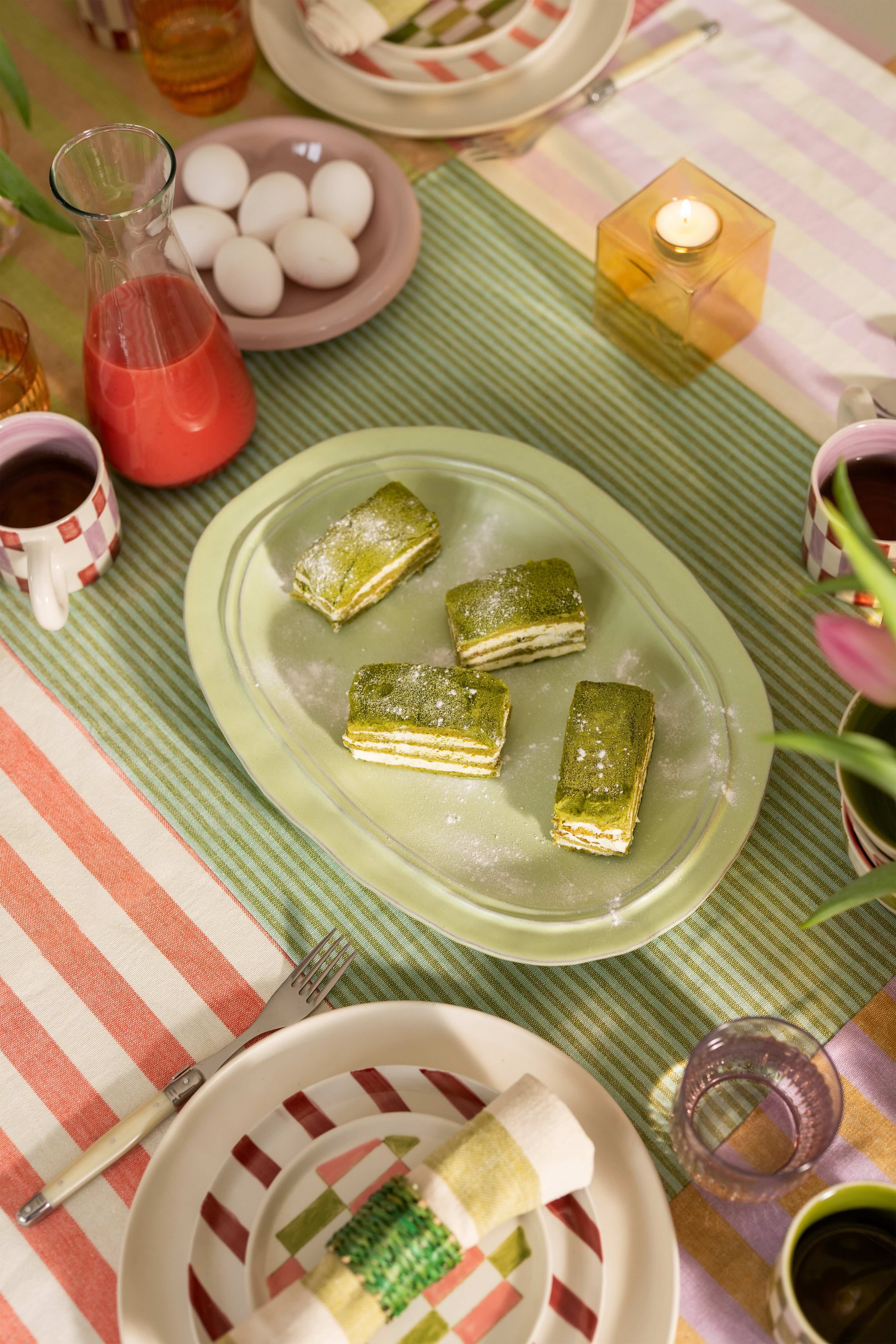 Kleurrijk servies met gebakjes op de paastafel