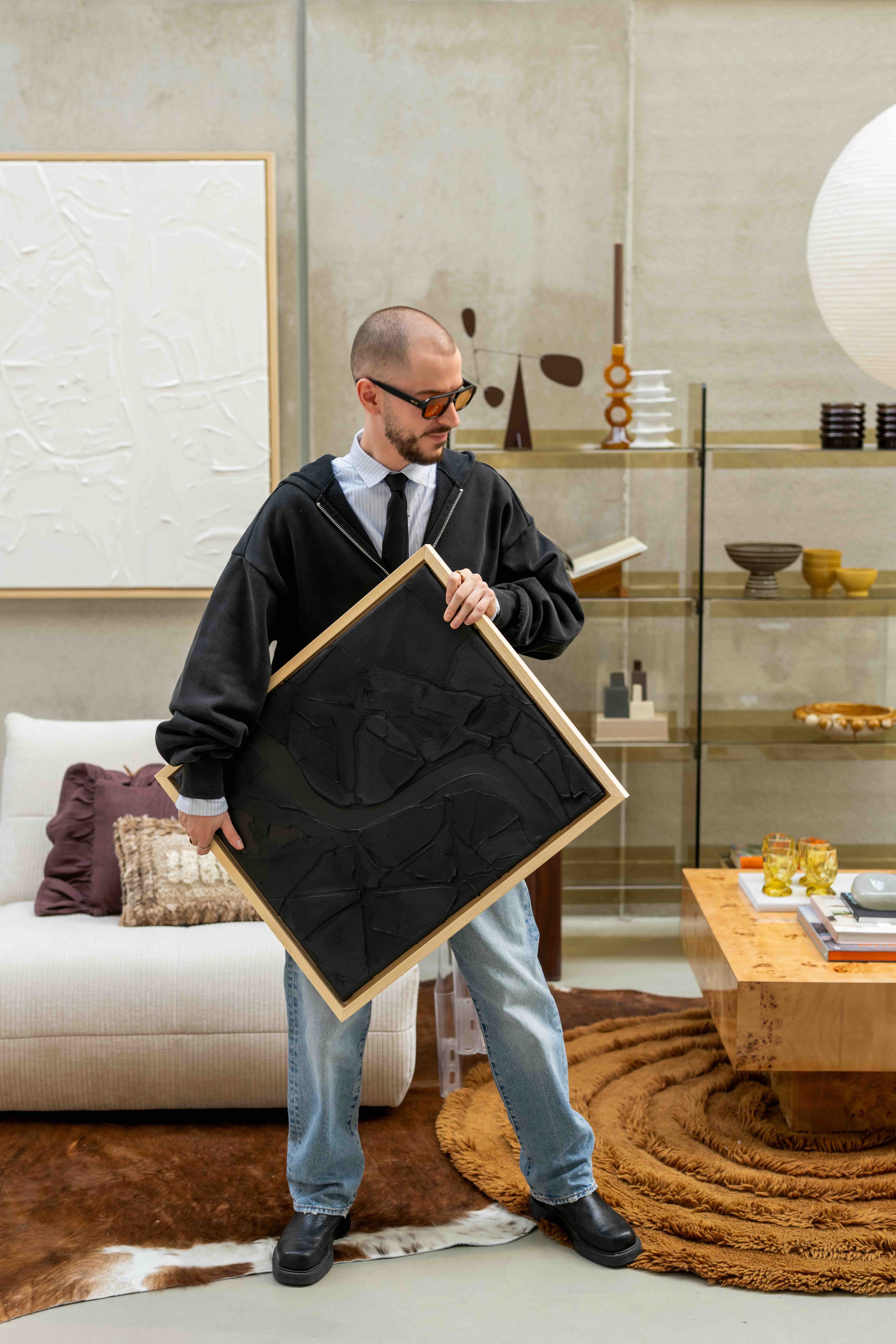 man staat met schilderij in armen