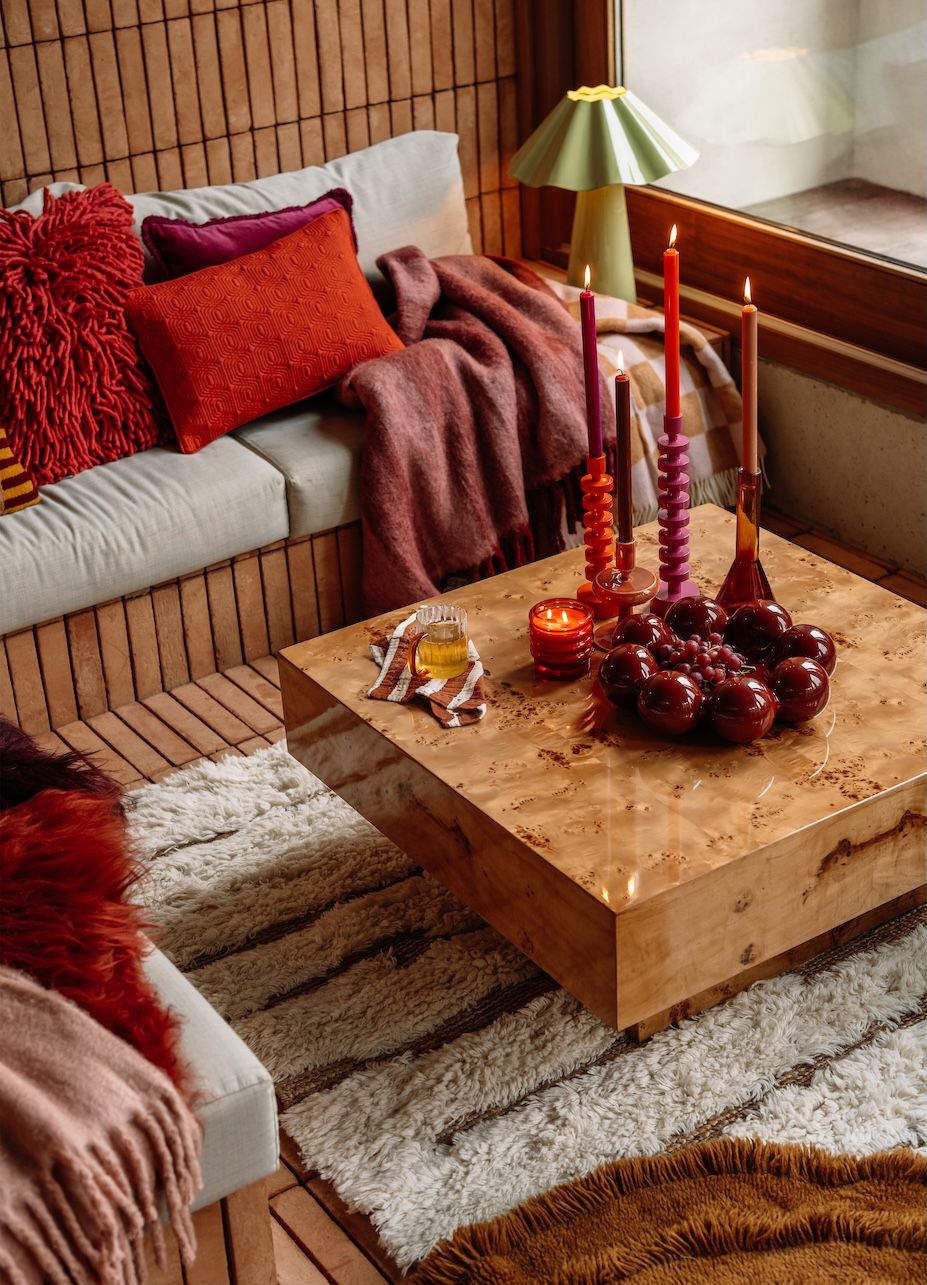 Woonkamer met salontafel, kaarsen en kussens