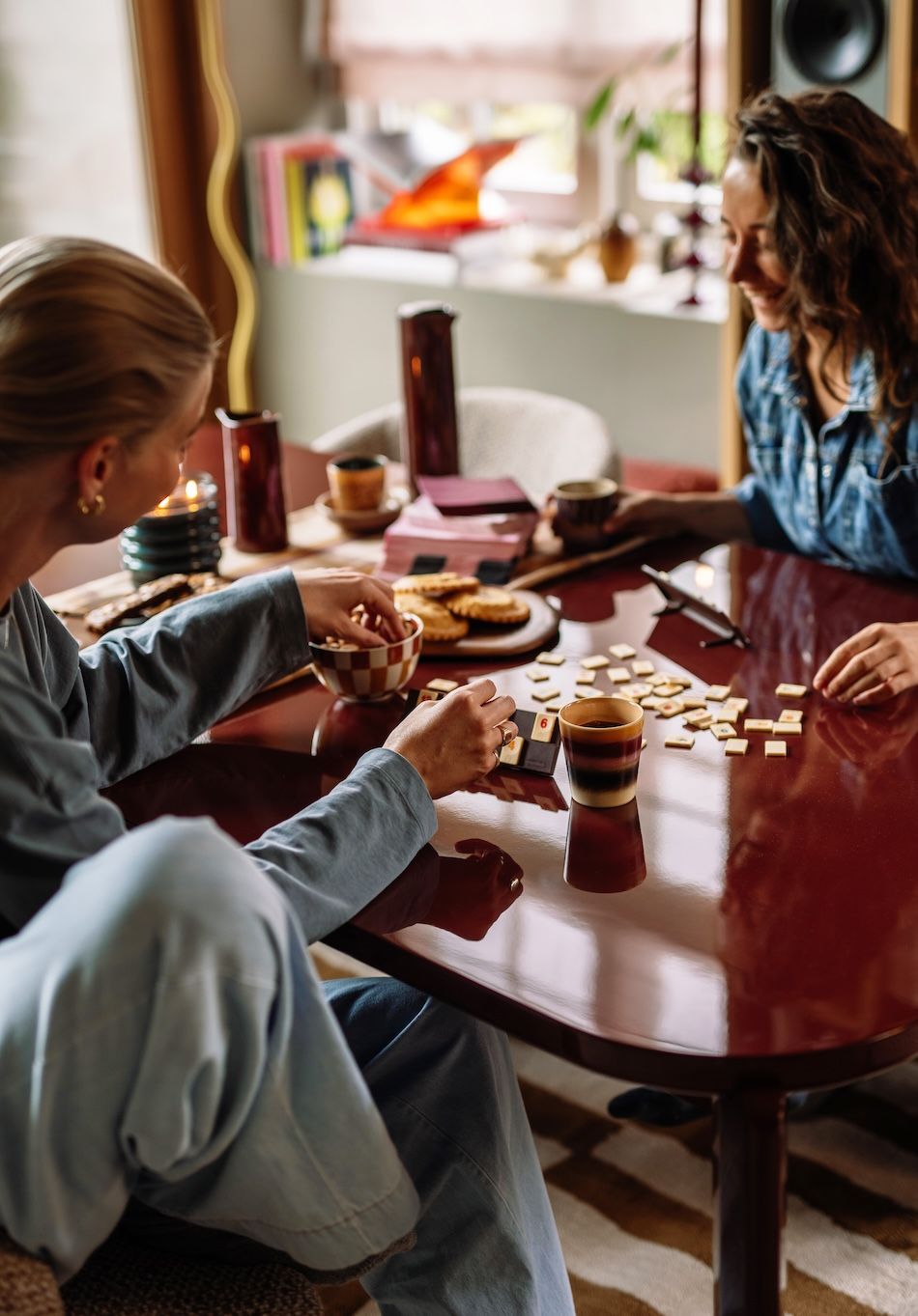 twee vrouwen zitten aan tafel en doen een spelletje