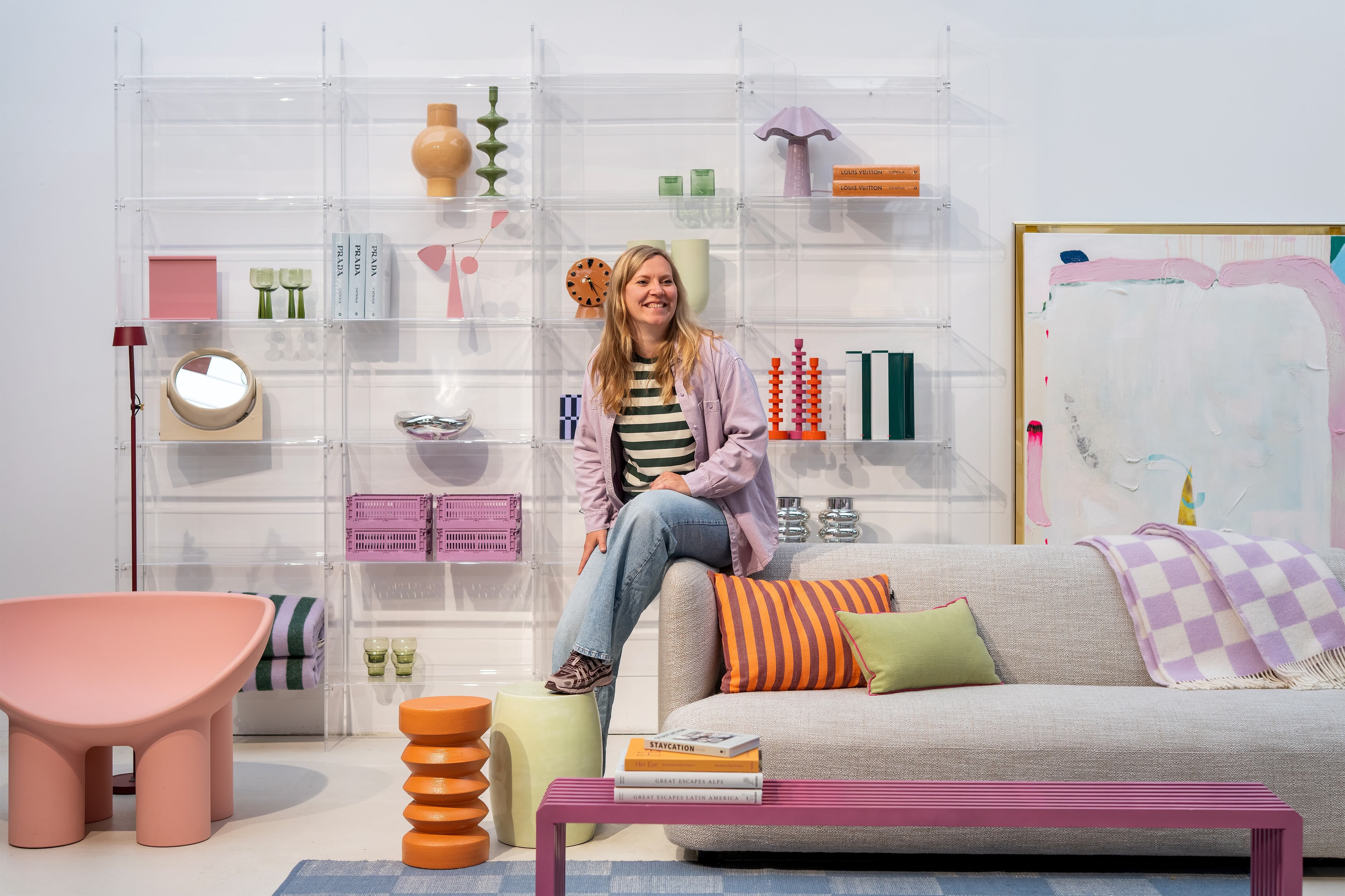 Pastel kleurige woonkamer met lachend persoon zittend op bank