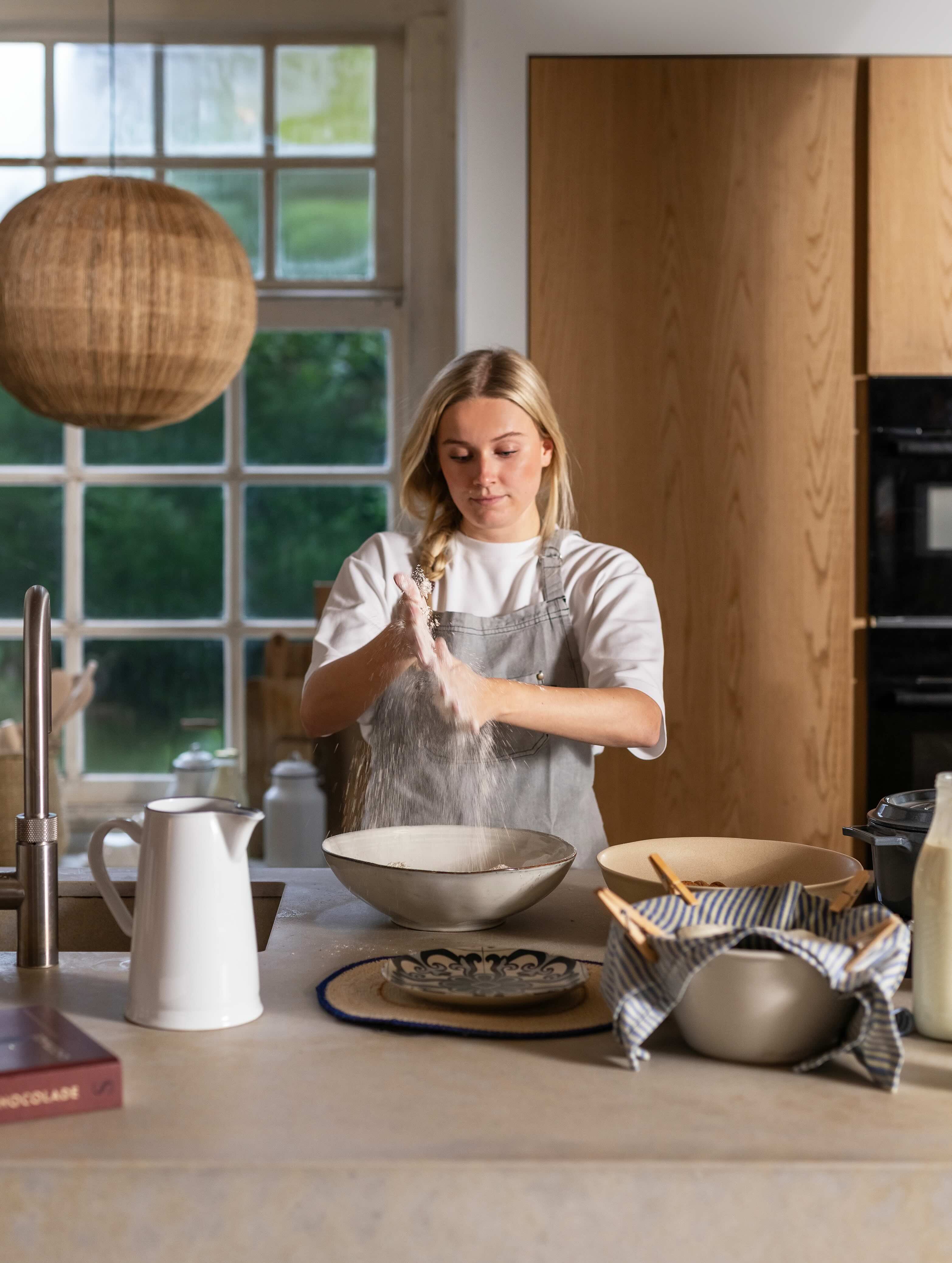 Blonde vrouw is aan het bakken in landelijke keuken