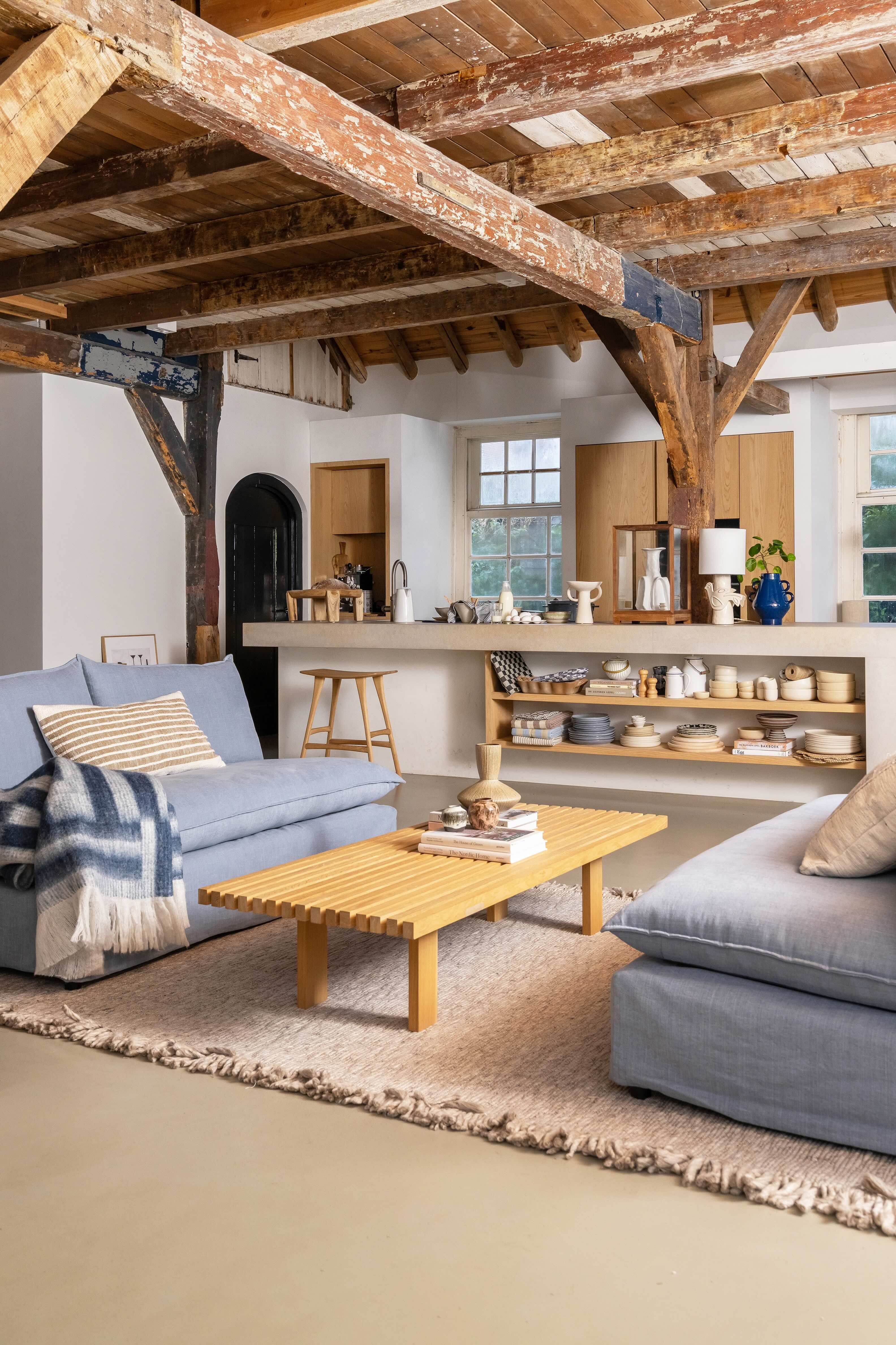 Groot kookeiland met daarvoor 2 lichtblauwe banken en houten salontafel