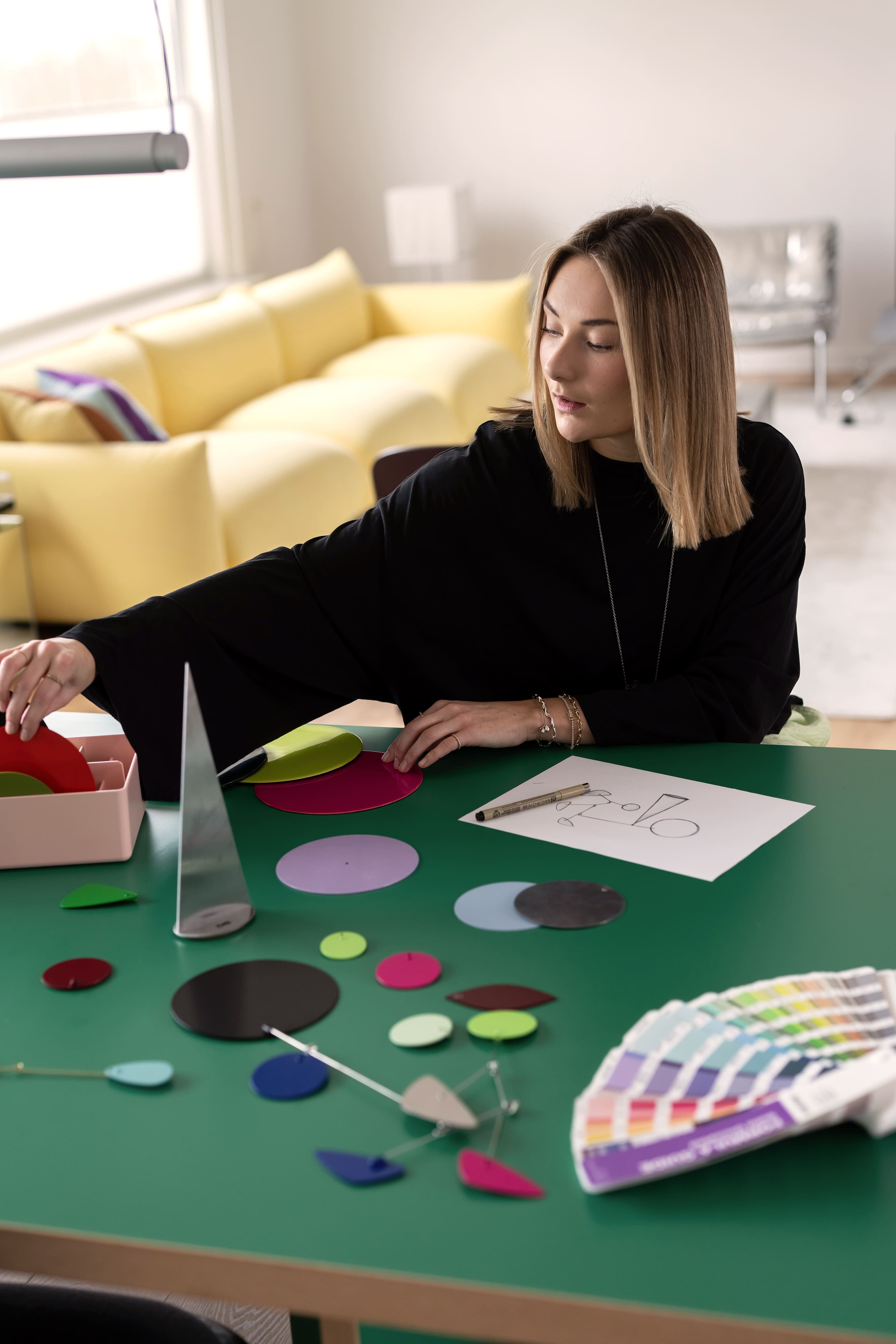 vrouw aan groene tafel met kleur samples
