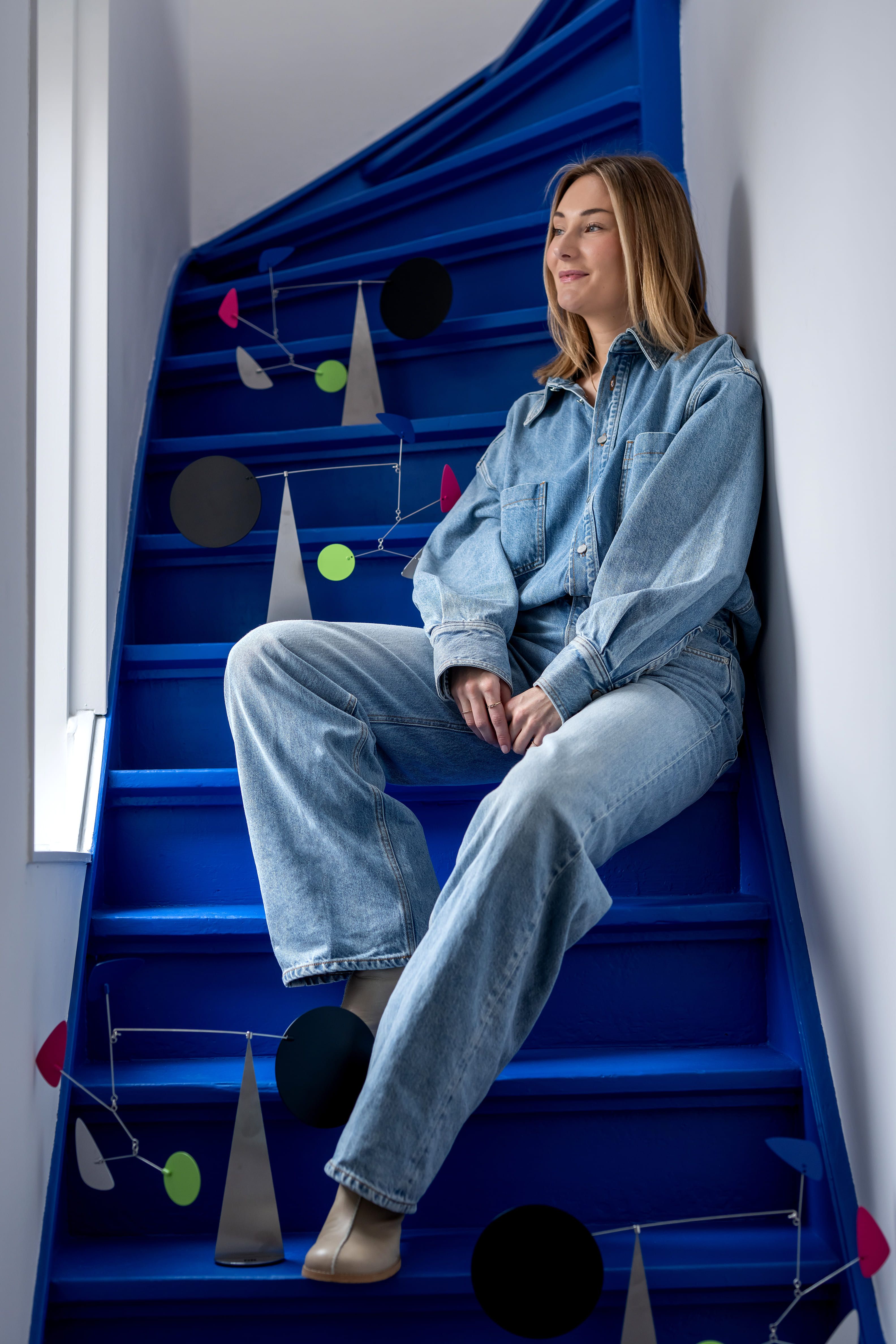 vrouw zit op blauwe trap