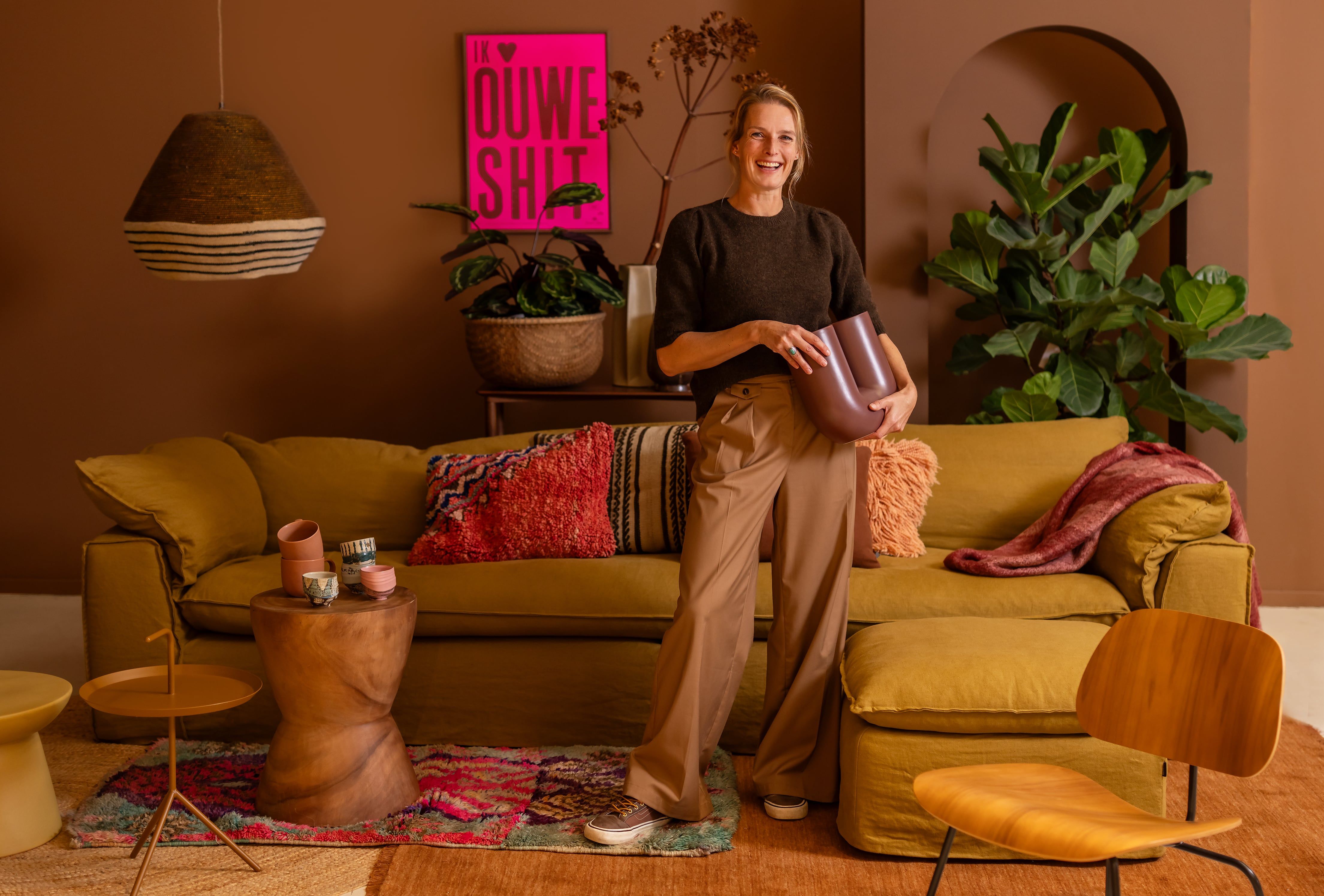 Vrouw staat met vaas in woonkamer