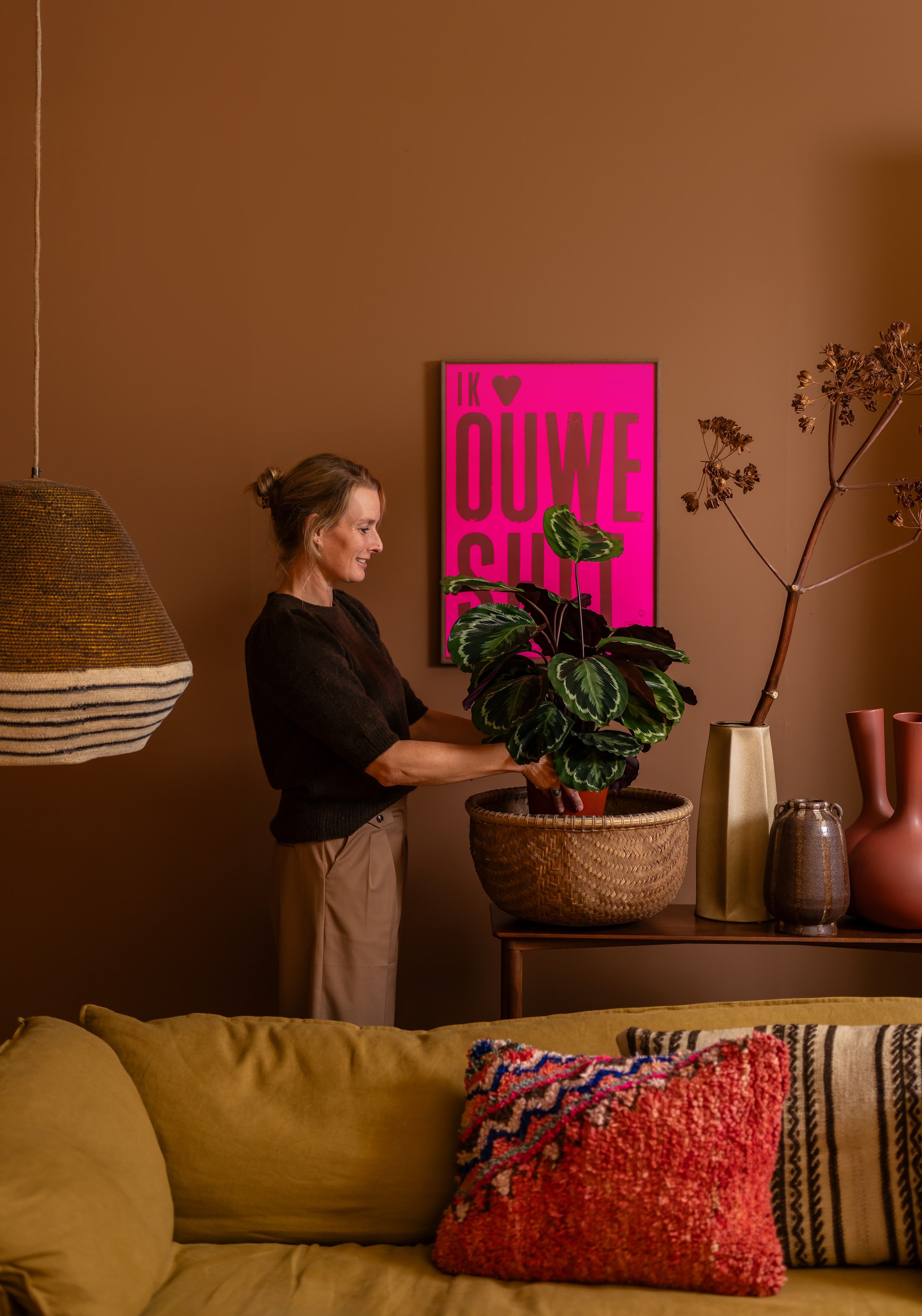 vrouw staat achter bank bij plant