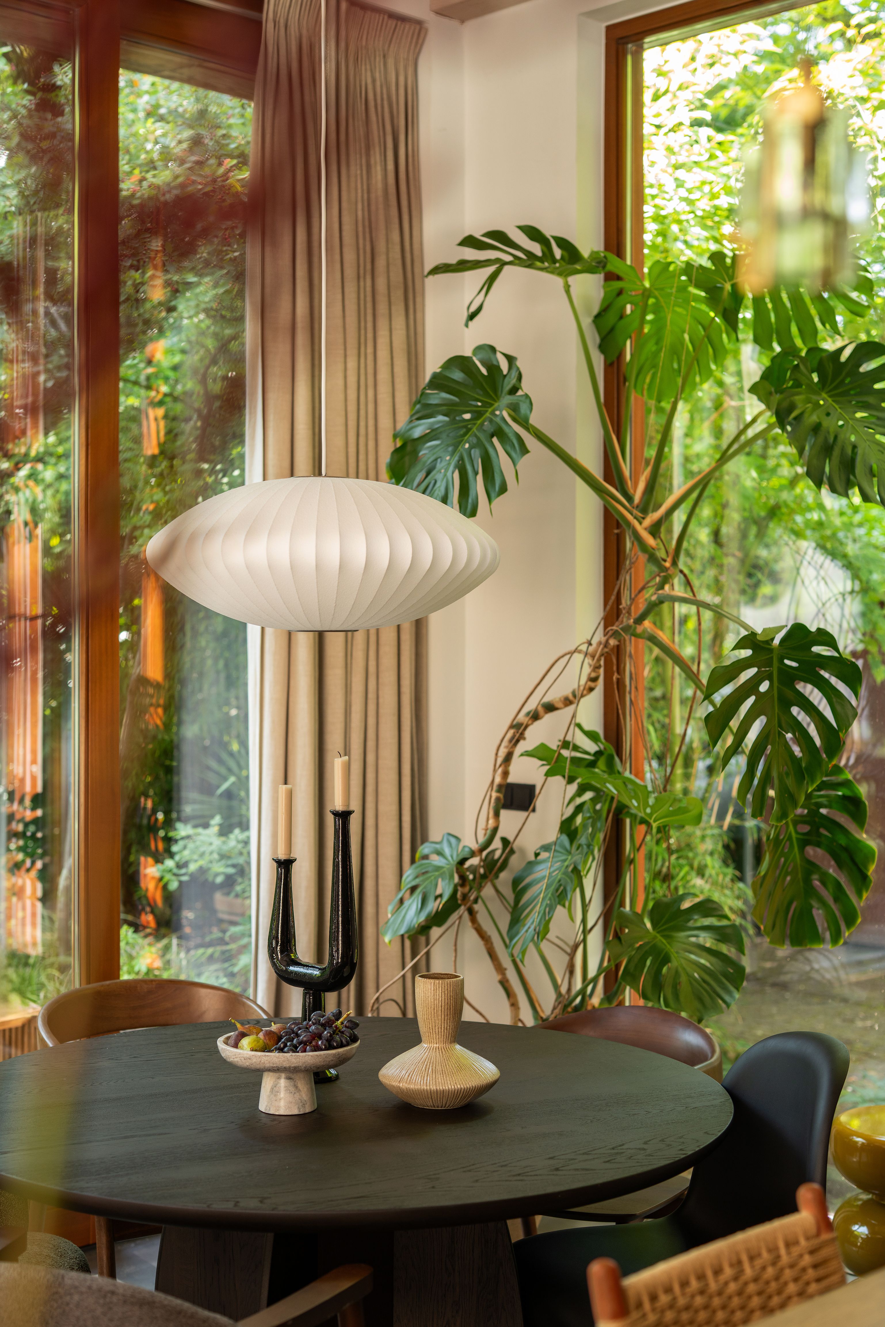 ronde eettafel met verschillende stoelen en hanglamp
