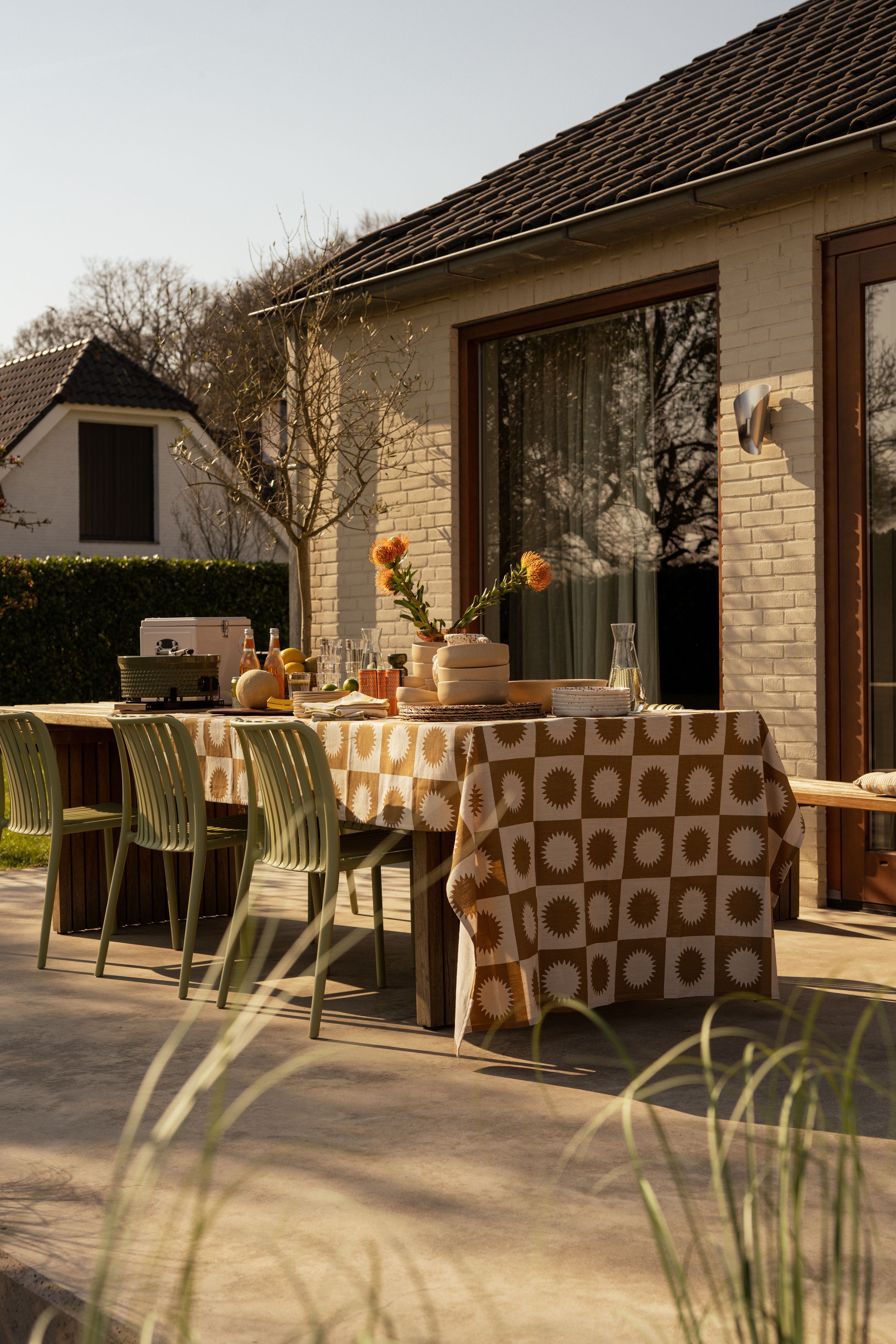 gedekte tafel in tuin met groene stoelen