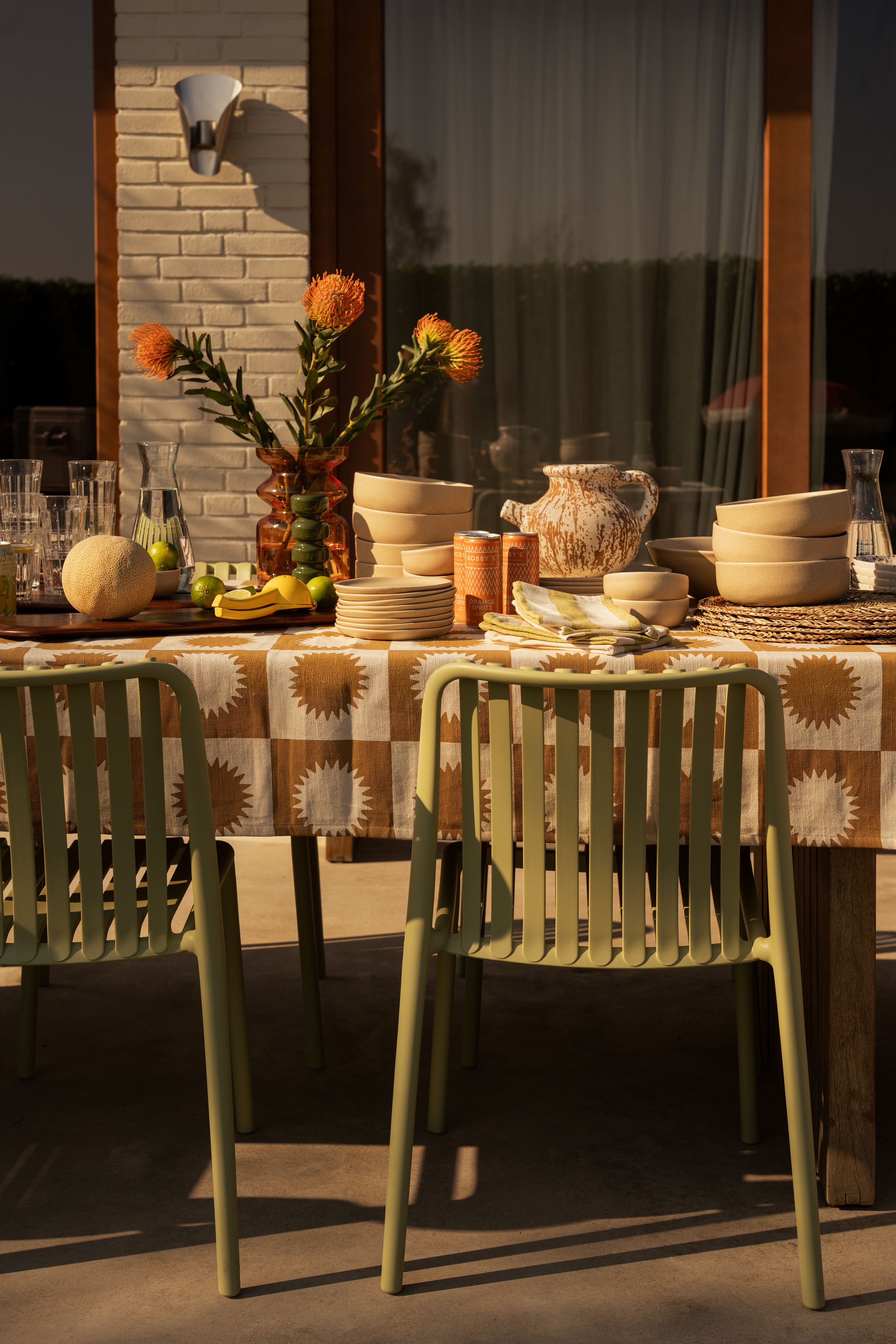 gedekte tafel in tuin met groene stoelen