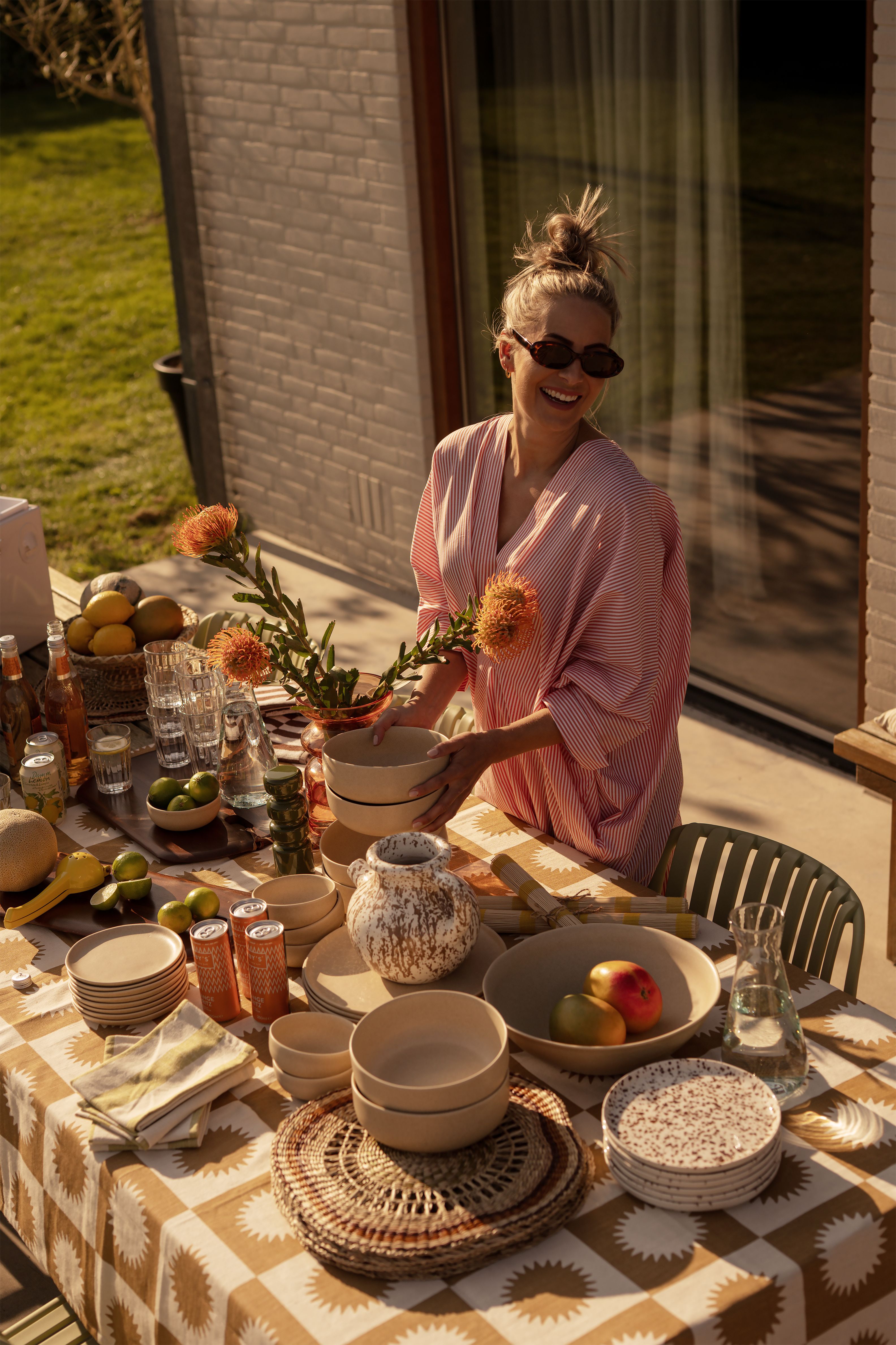 vrouw zit aan gedekte tafel in tuin