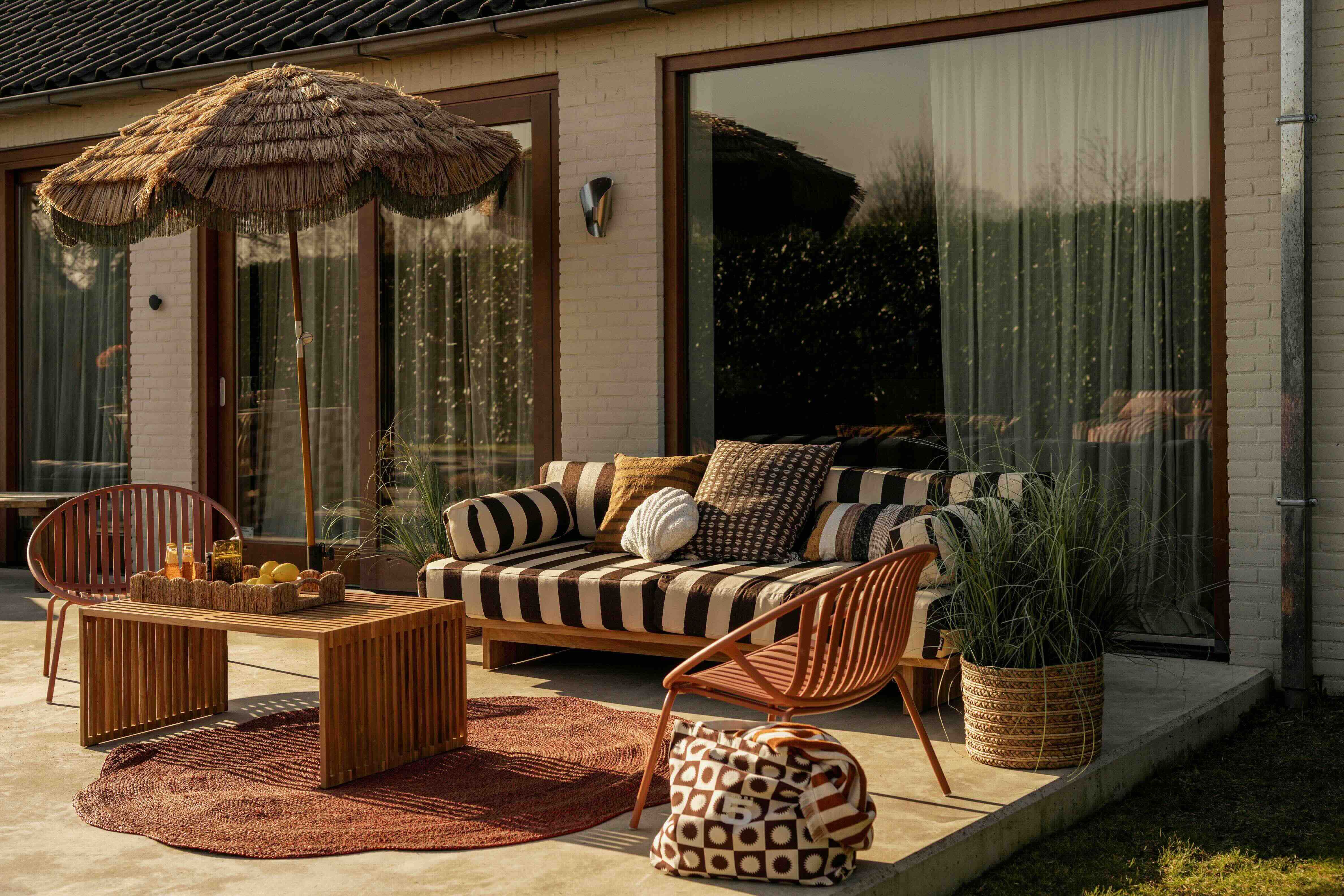 Gestreepte loungebank met vloerkleed en parasol