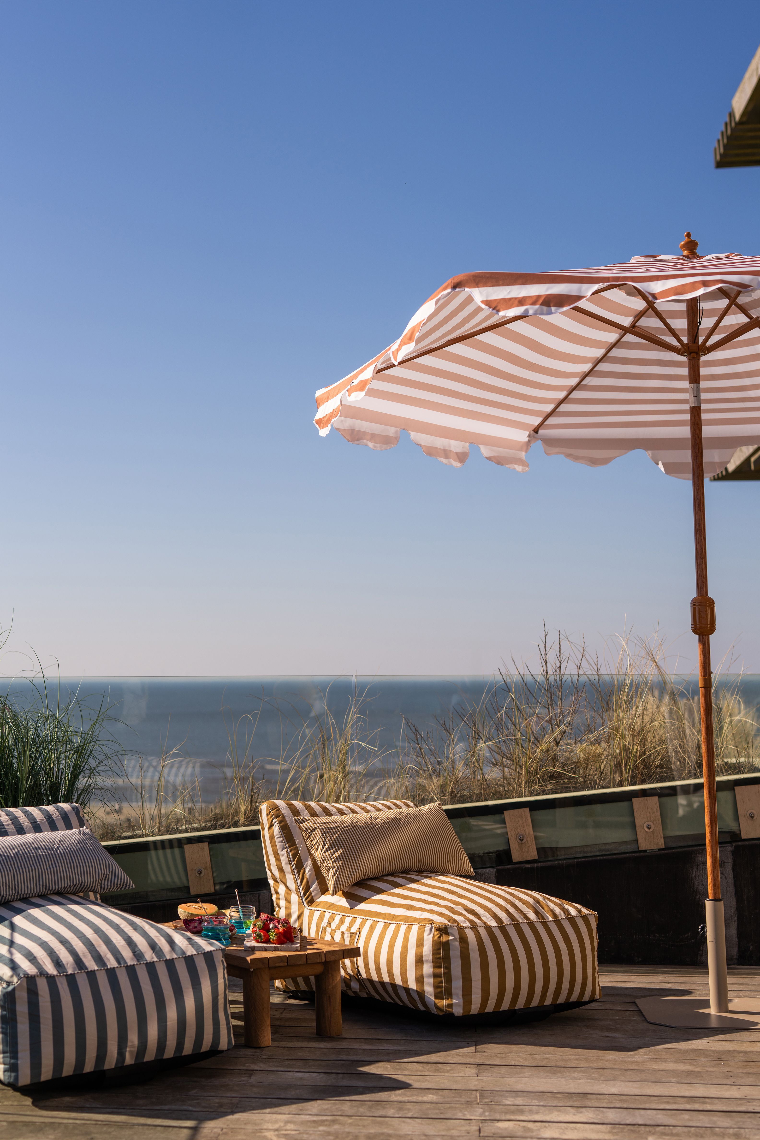 Gestreepte loungebedden met parasol