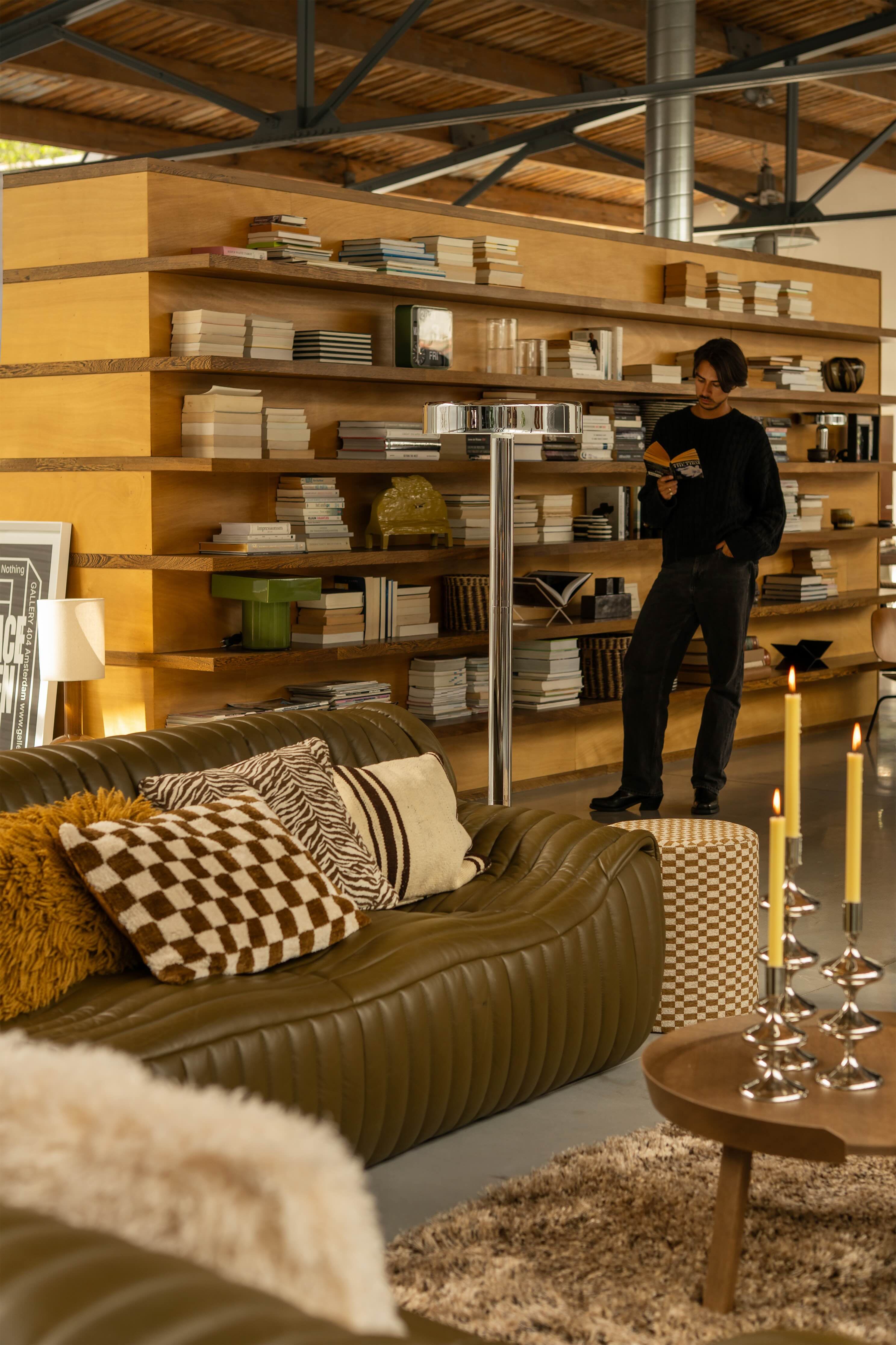 Woonkamer met leren bank en grote boekenkast