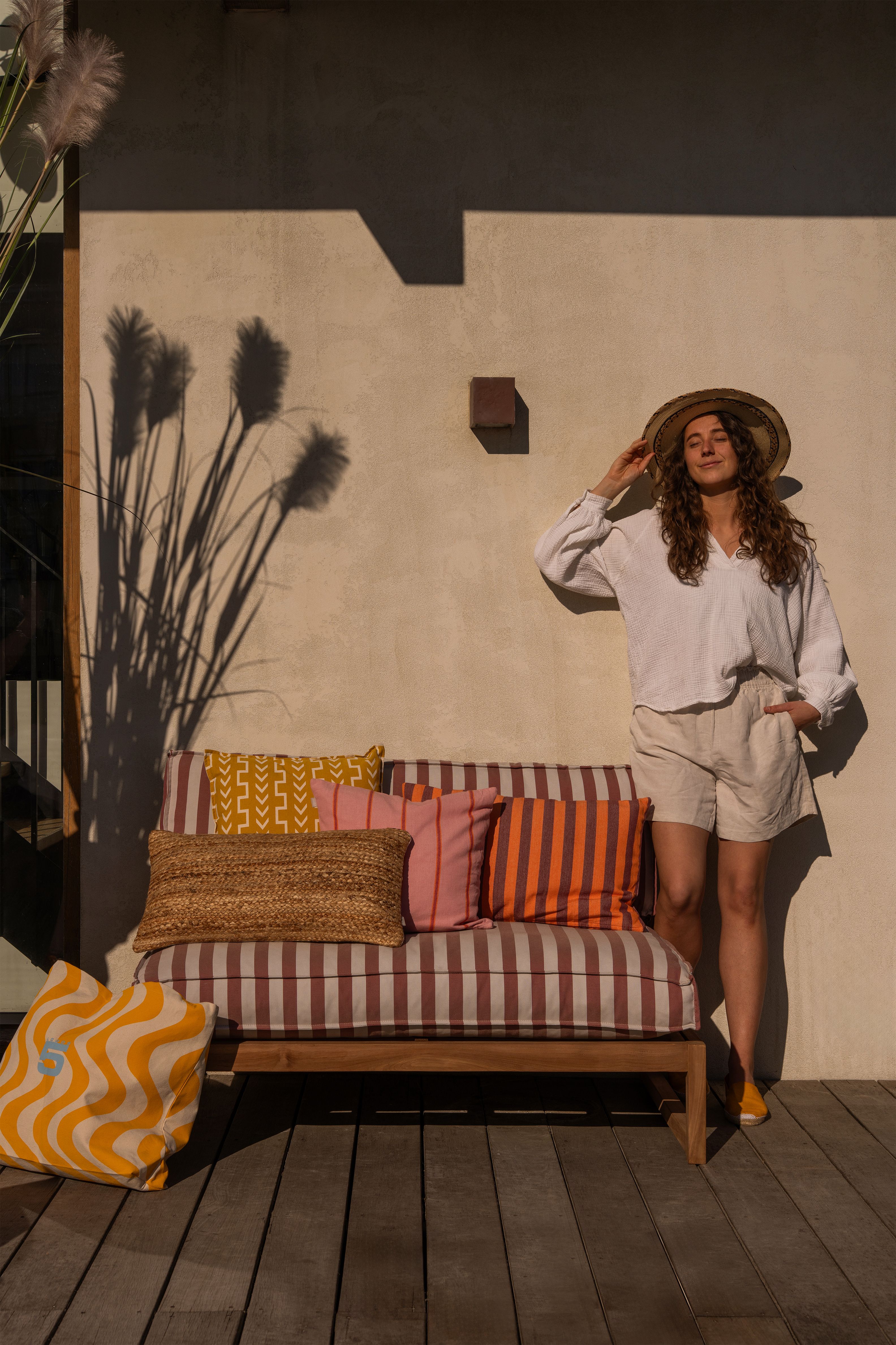 Gestreepte loungestoel met vrouw die aan het genieten is van de zon