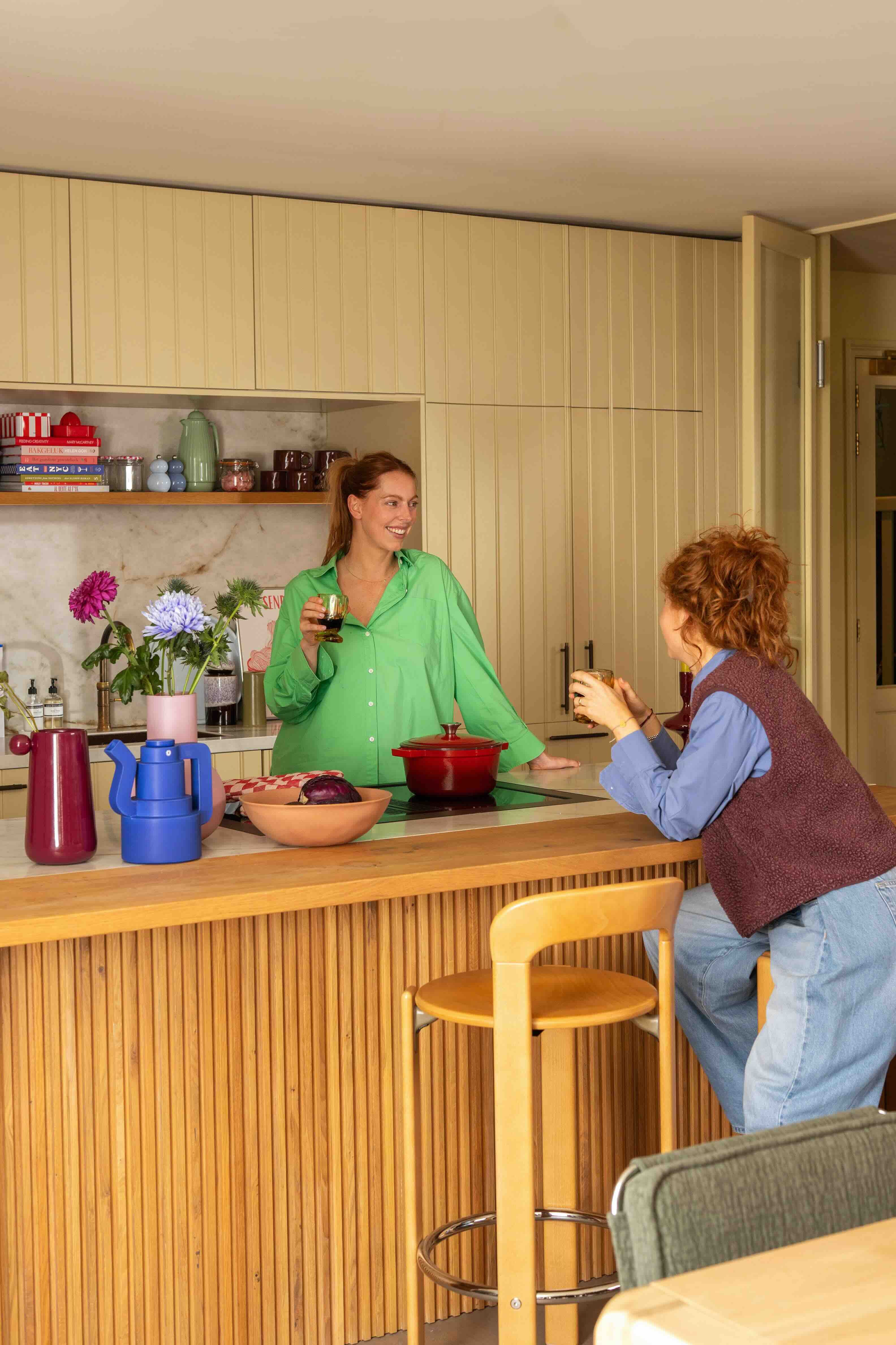vrouwen kletsen bij kookeiland