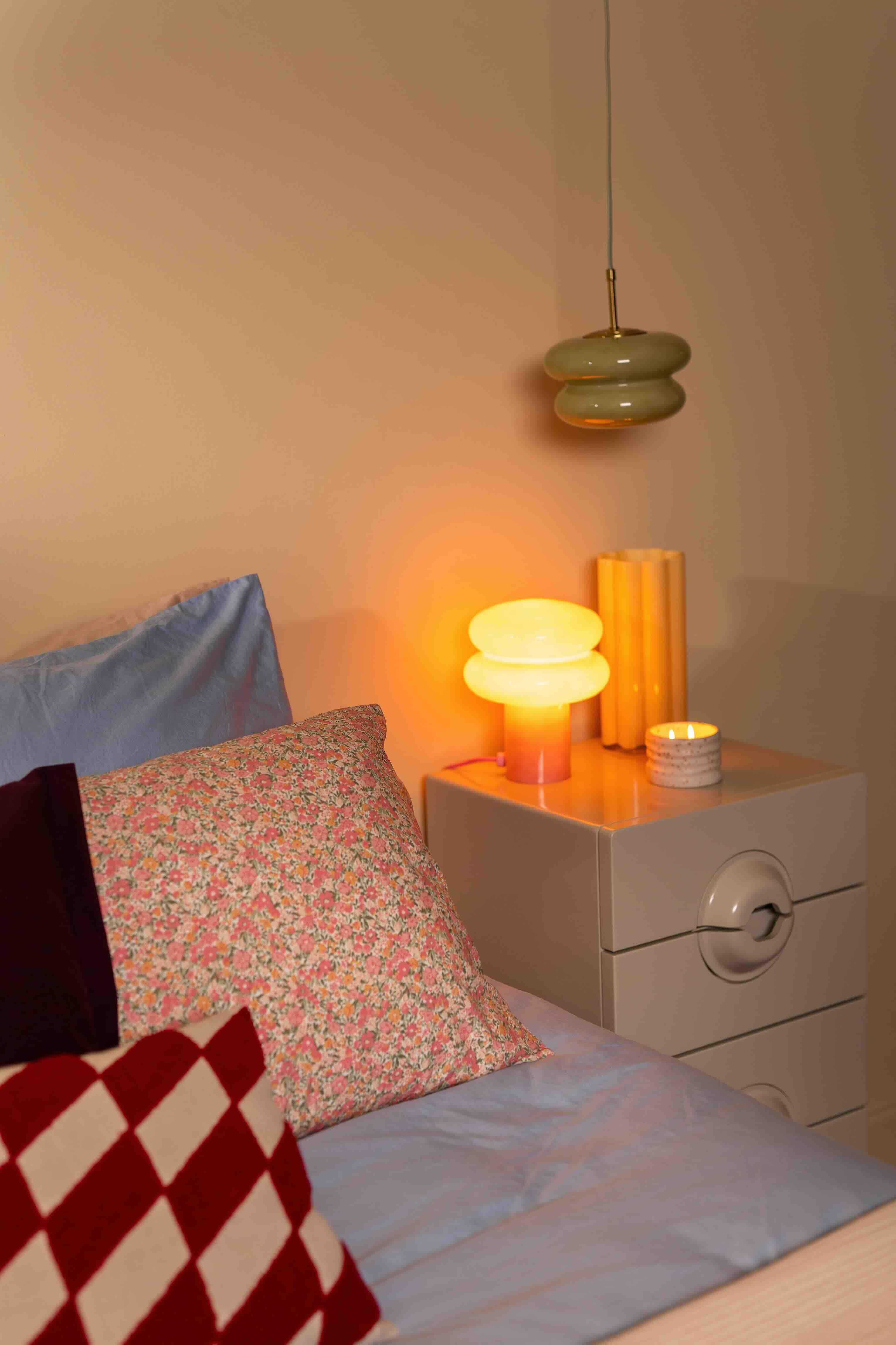 nachtkastje naast bed met lamp