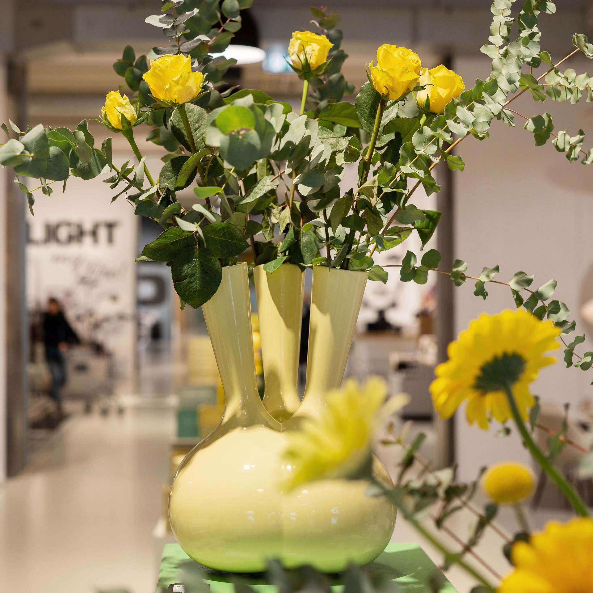 Gele designvaas va Roderick Vos met gele bloemen erin