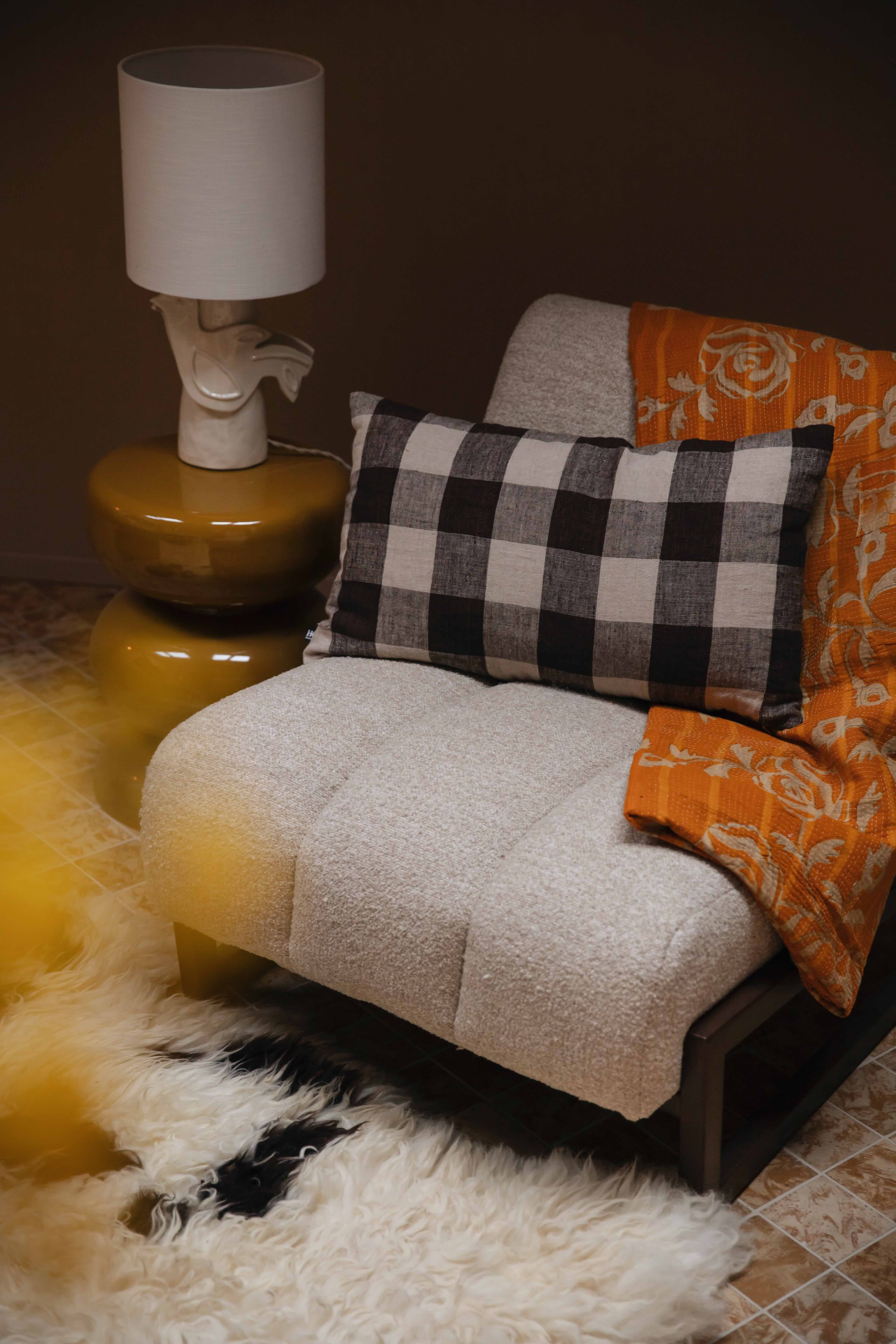 Zithoek met fauteuil, kussen, plaid, bijzettafel en lampje