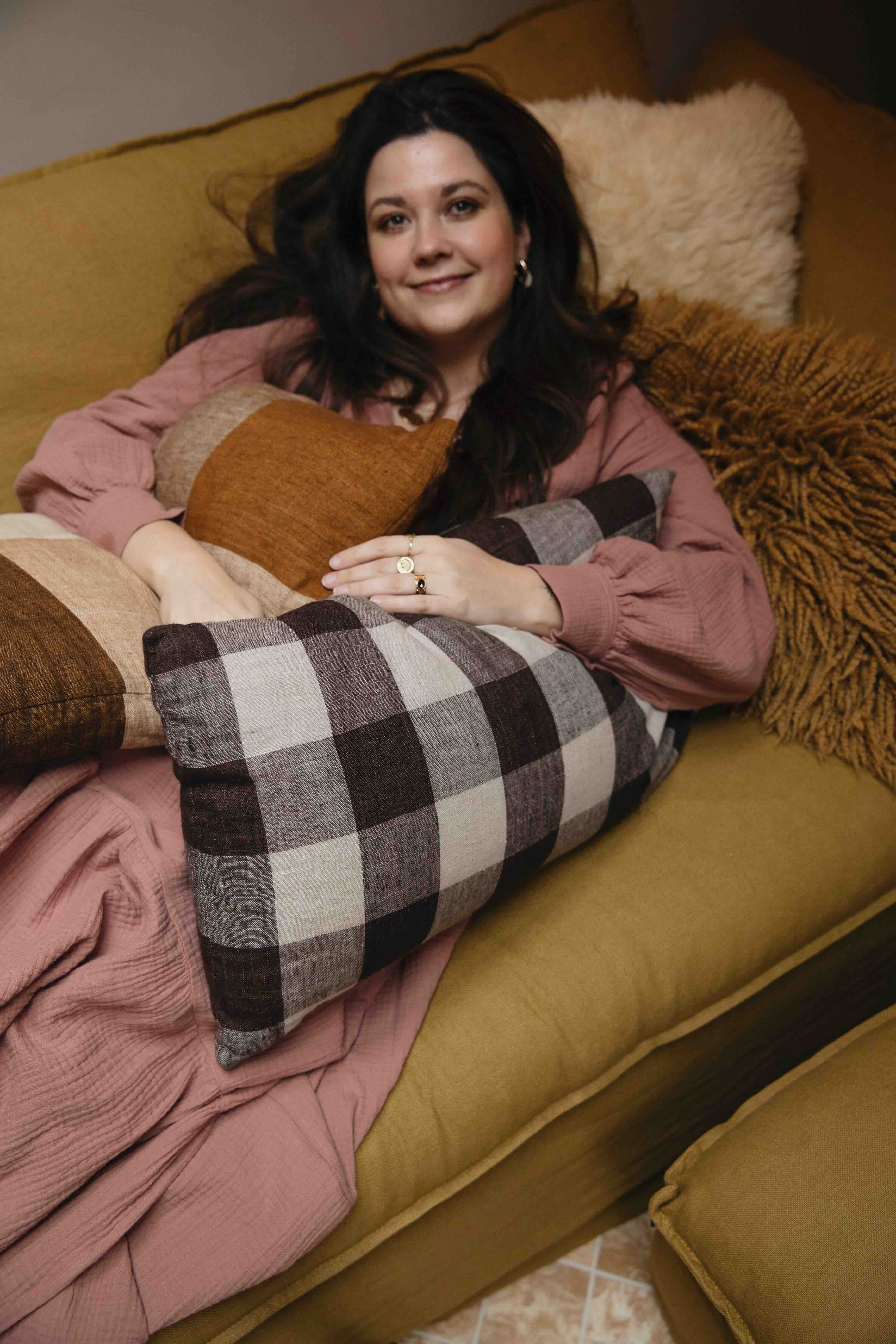 Nina Nijland op bank met kussens van HKliving