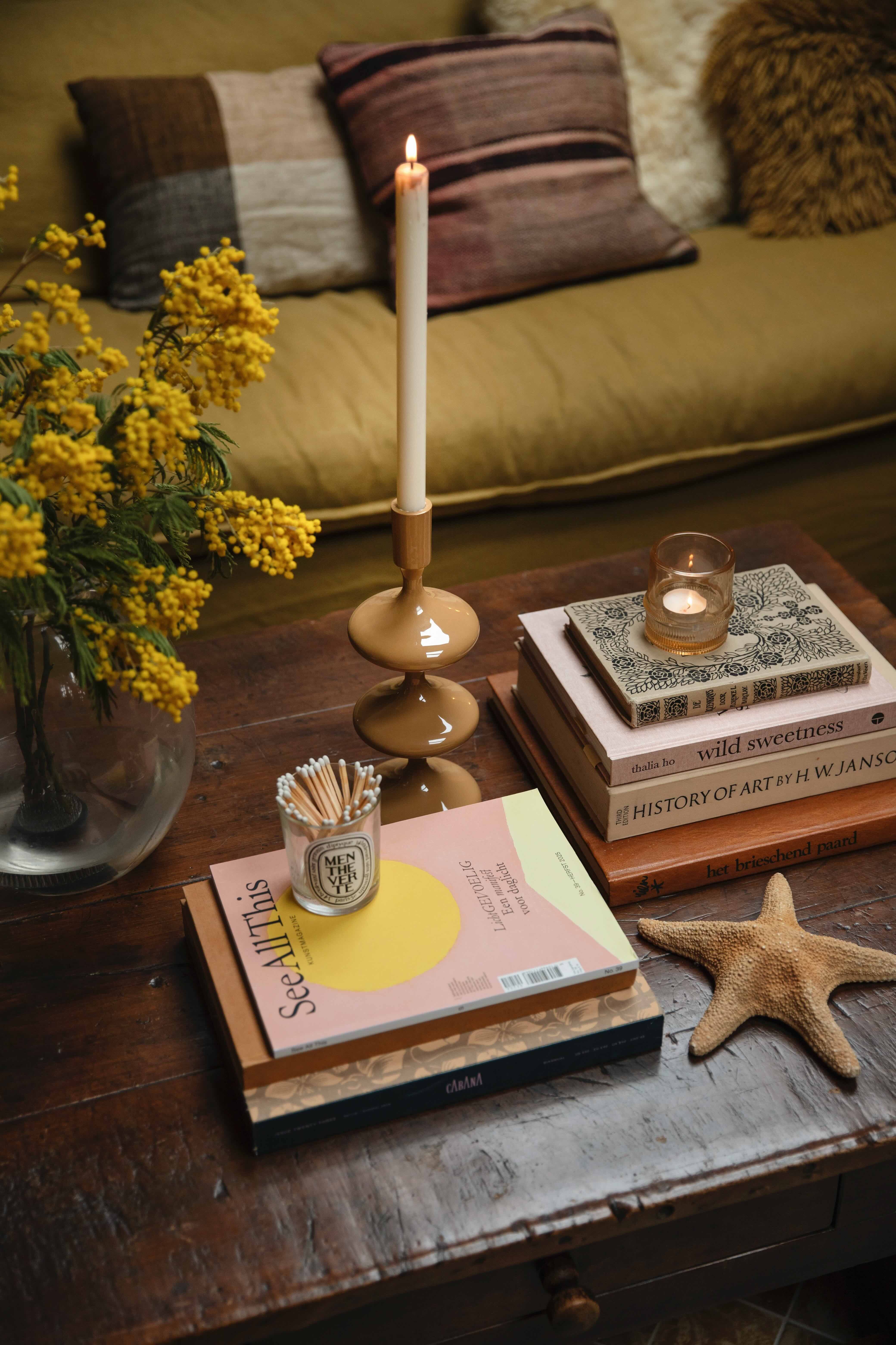 Koffietafelboeken op houten tafel met kandelaar