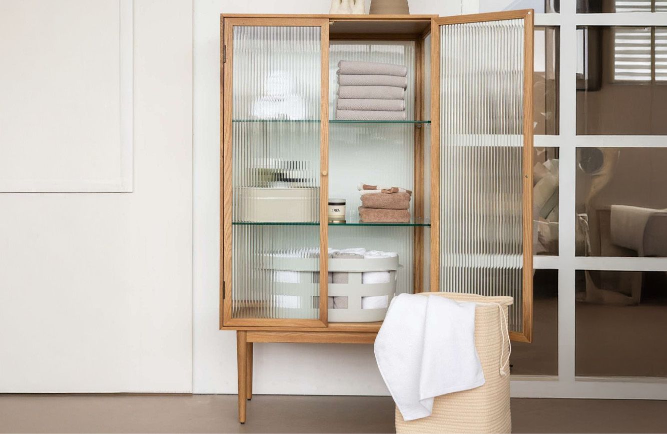 Vitrine kast met glazen deuren en handdoeken