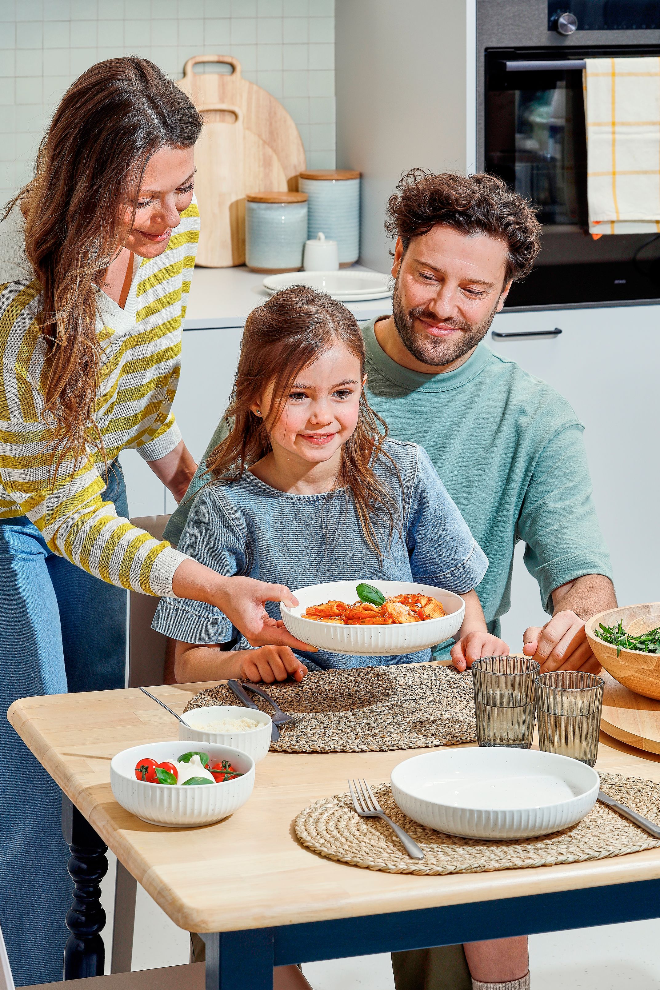Gezin van 3 met servies aan de tafel